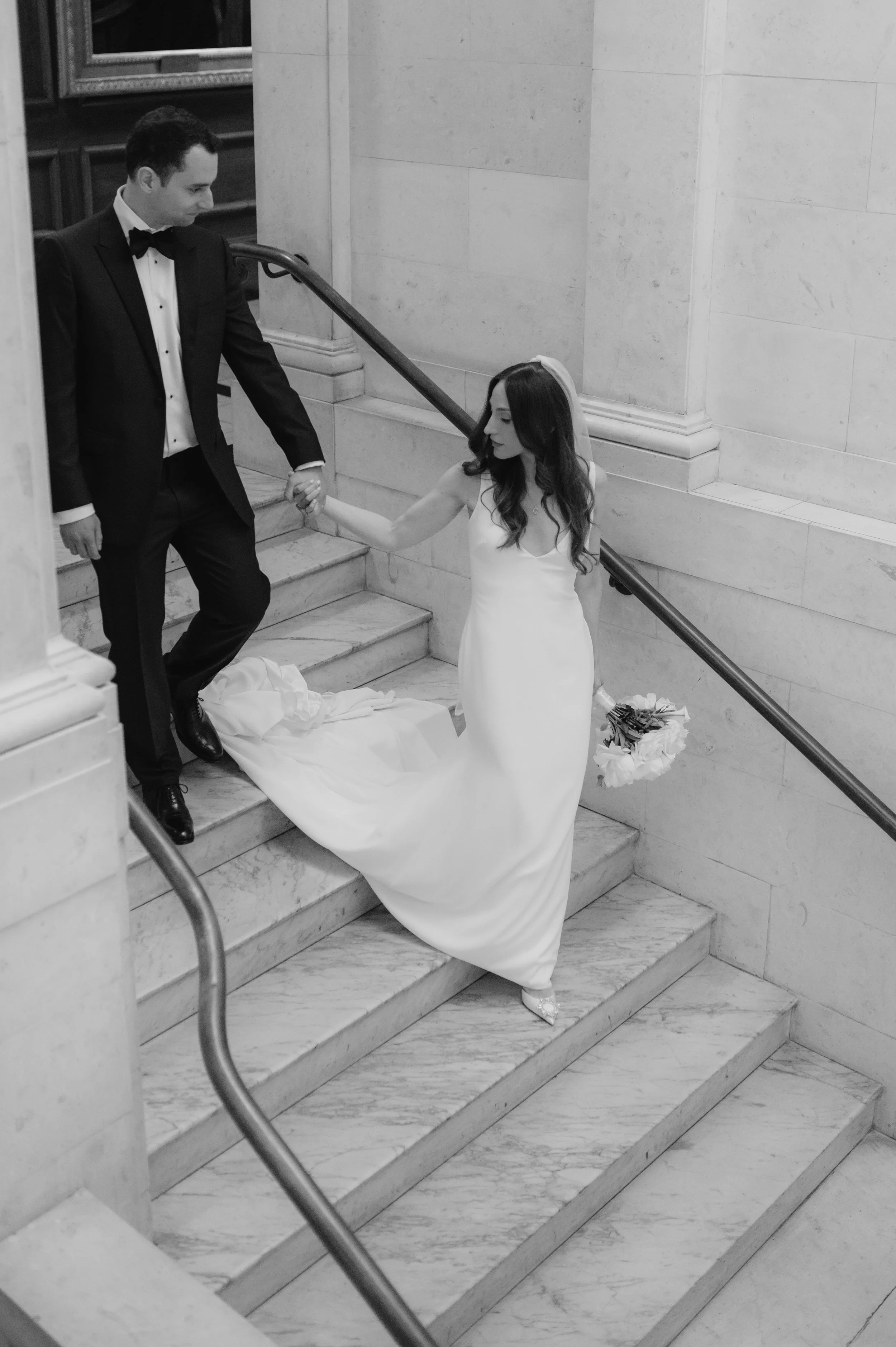 London wedding photography at Marylebone Town Hall bride leading groom down stairs