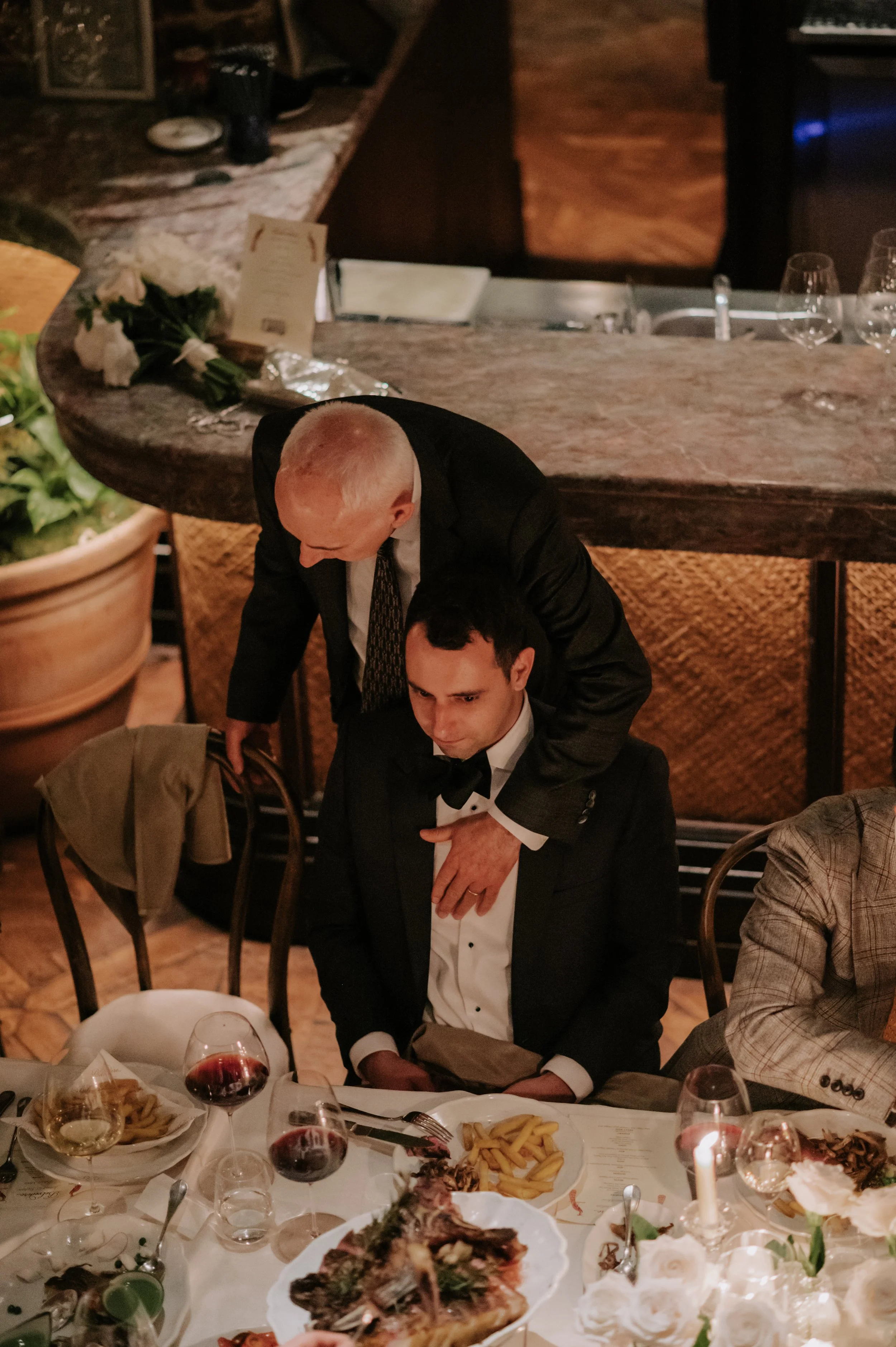 candlelit dinner London wedding photography at Belvedere in Holland Park groom dad hugging groom 