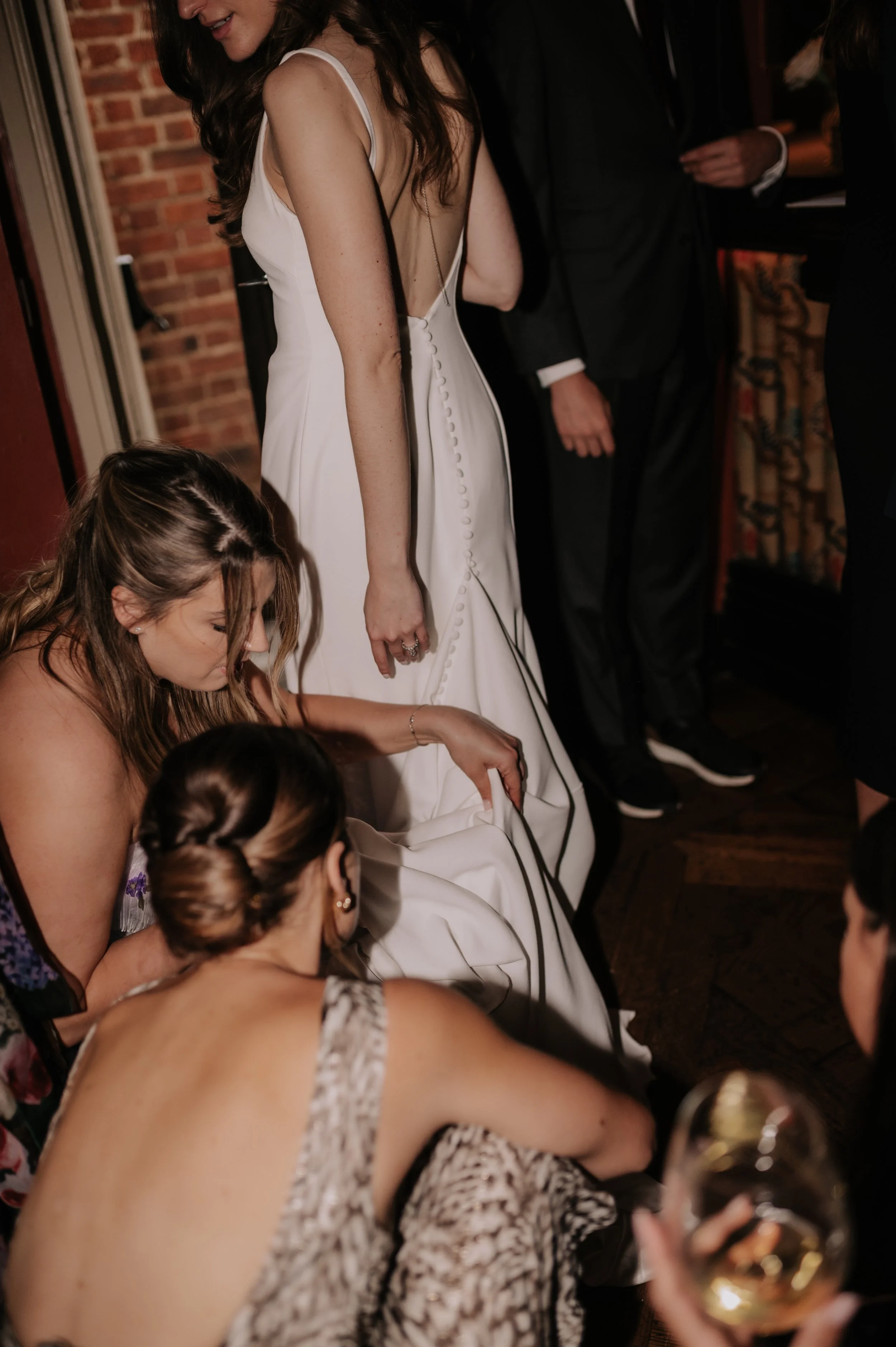 London wedding photography at Belvedere in Holland Park girls fixing bride's dress