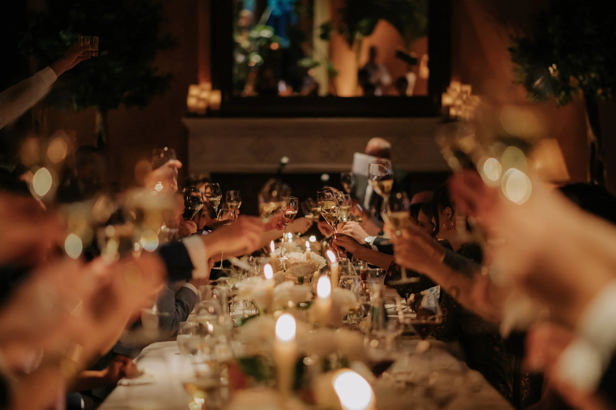 candlelit dinner London wedding photography at Belvedere in Holland Park guests clinking glasses over table 