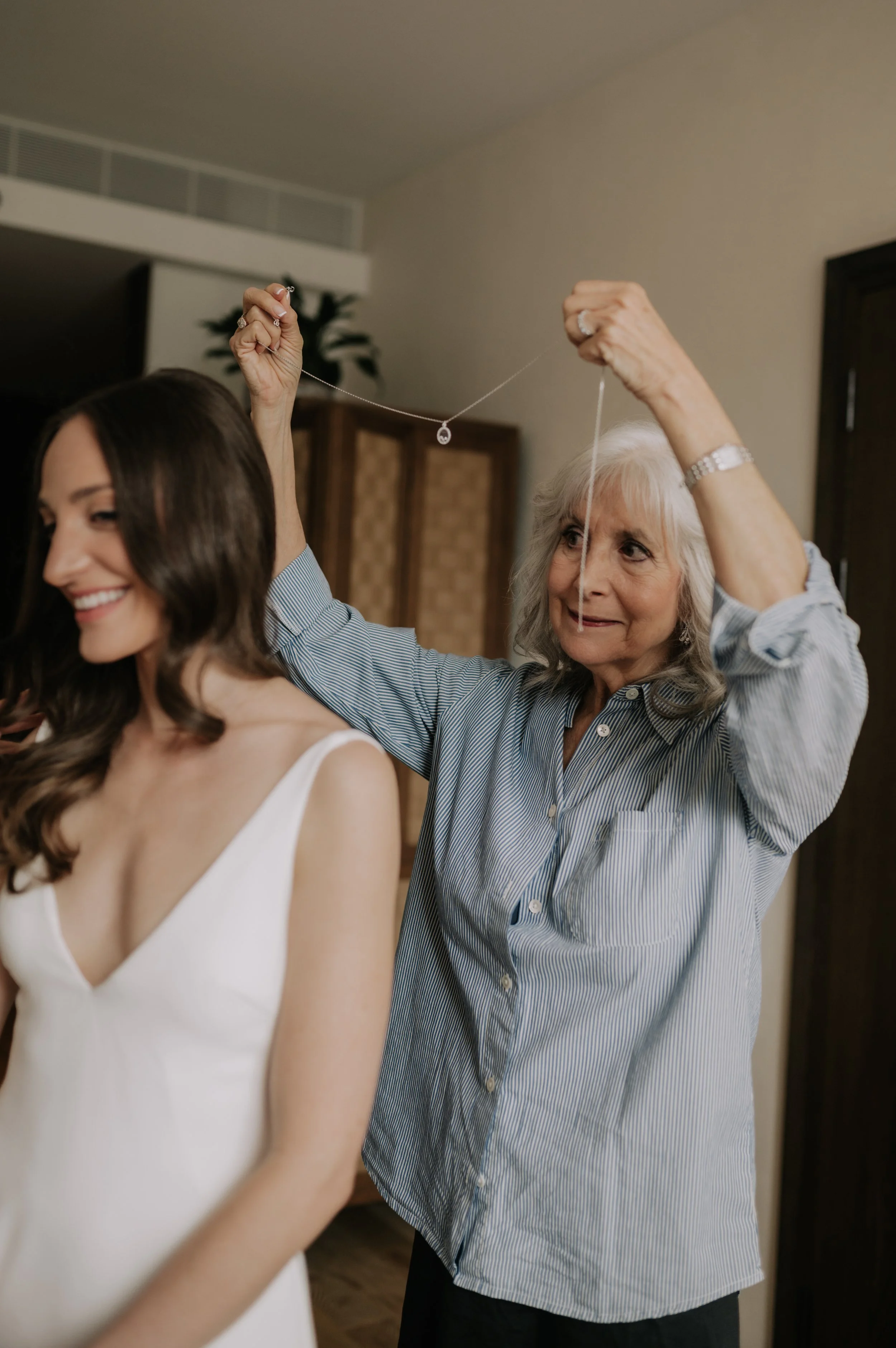 London wedding at Marylebone Town Hall woman holding necklace over bride