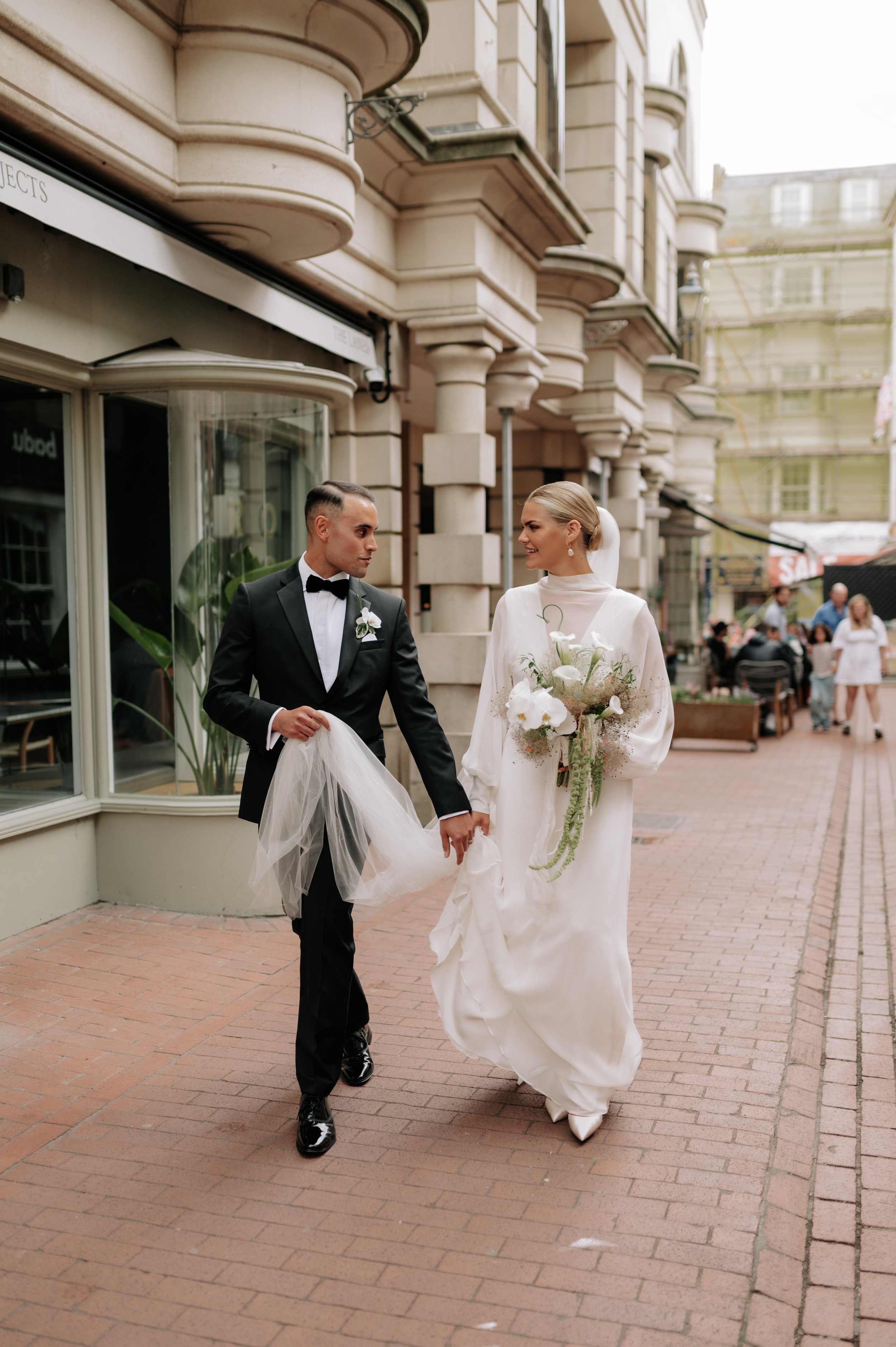 Bride and groom waling through the lanes at Brighton wedding. Fine art documentary wedding photography. 