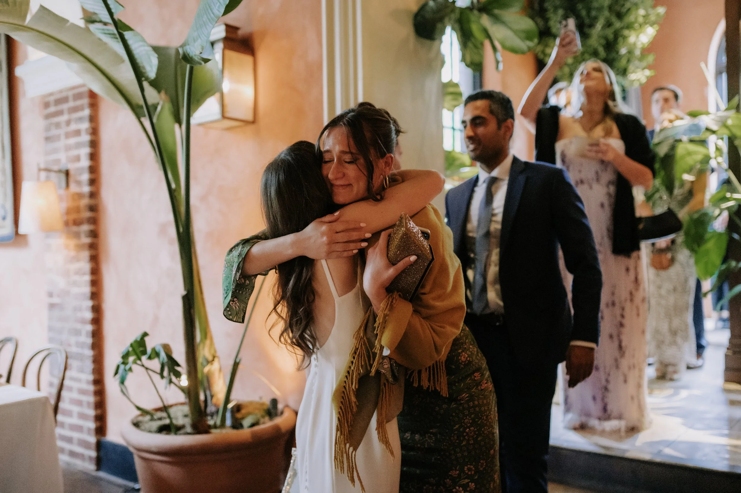 London wedding photography at Belvedere in Holland Park guest hugging bride 