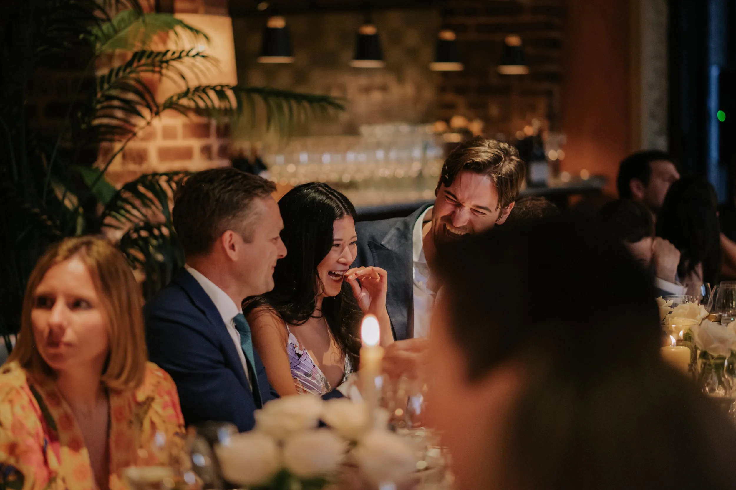 candlelit dinner London wedding photography at Belvedere in Holland Park guest laughing 