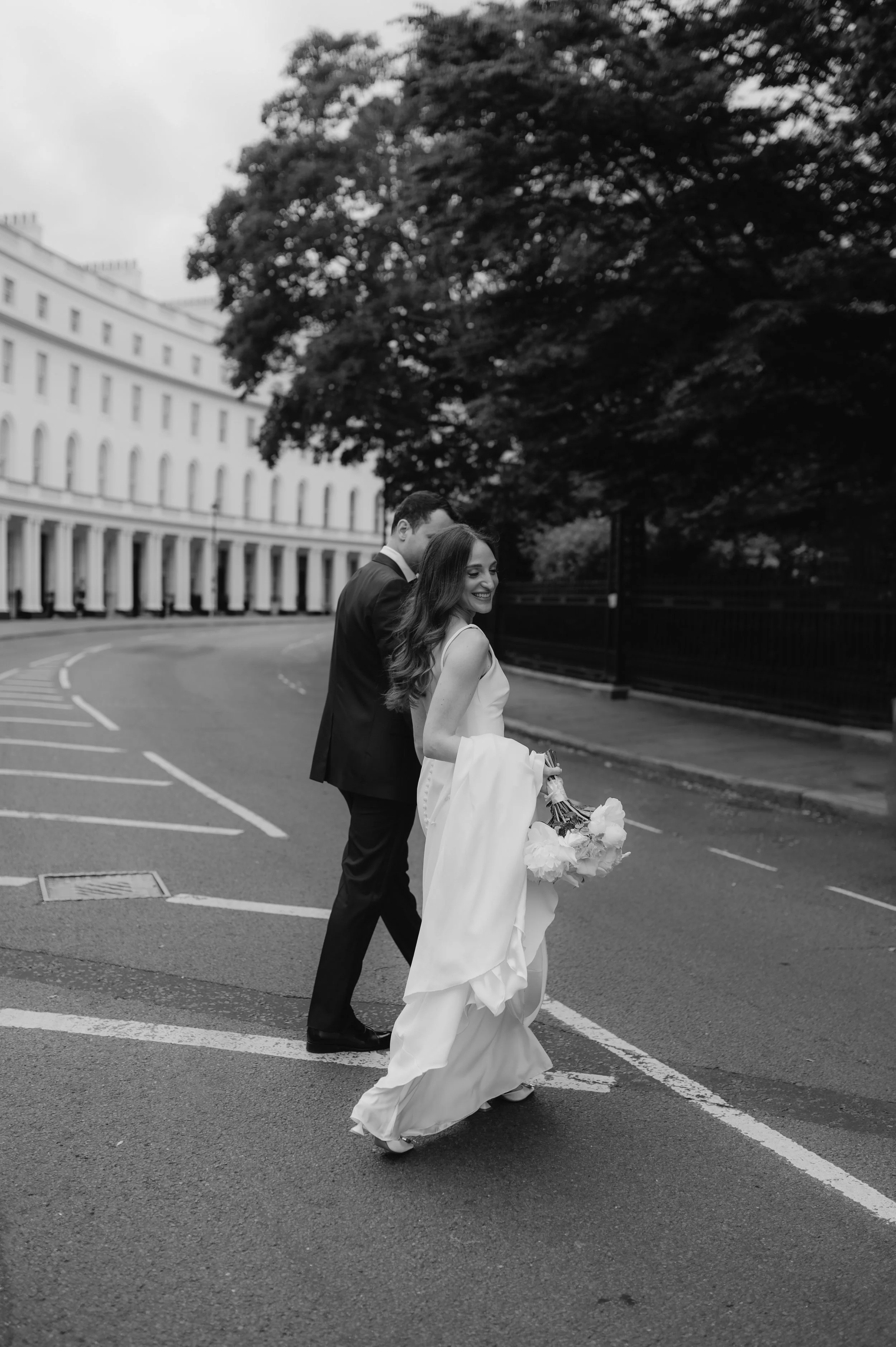 London wedding photography at Marylebone Town Hall bride and groom walking across road and bride looking back over shoulder