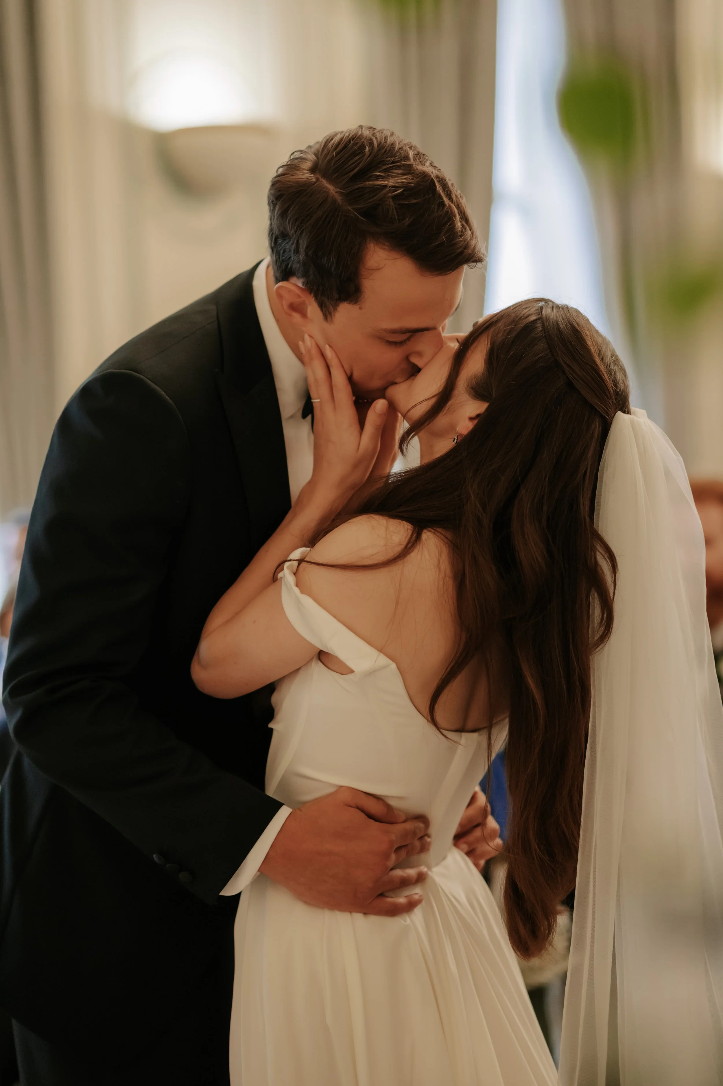 bride and groom embrace in their first kiss at their wedding ceremony in London