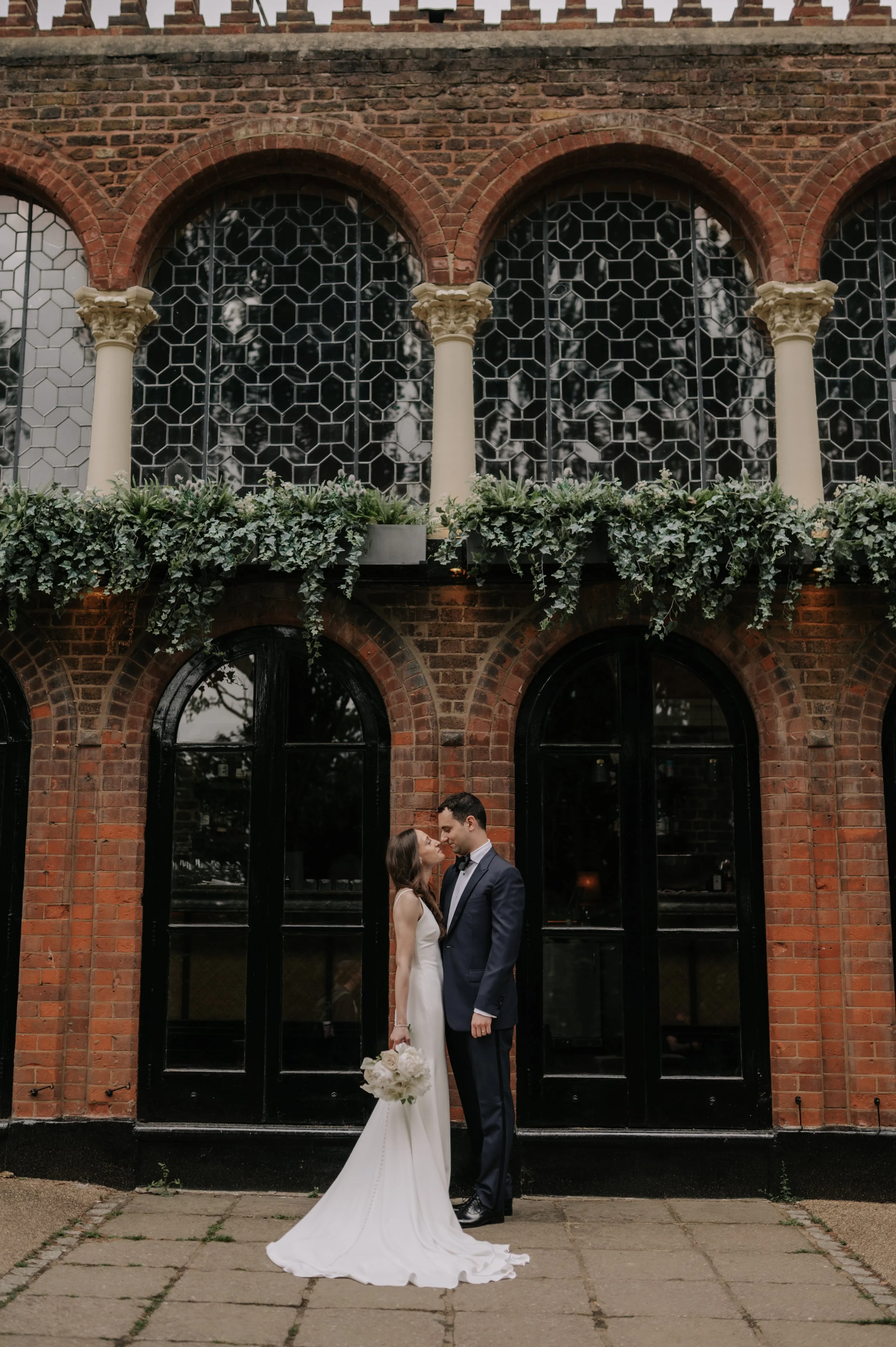 London wedding photography at Belvedere in Holland Park bride and groom kissing outside restaurant 