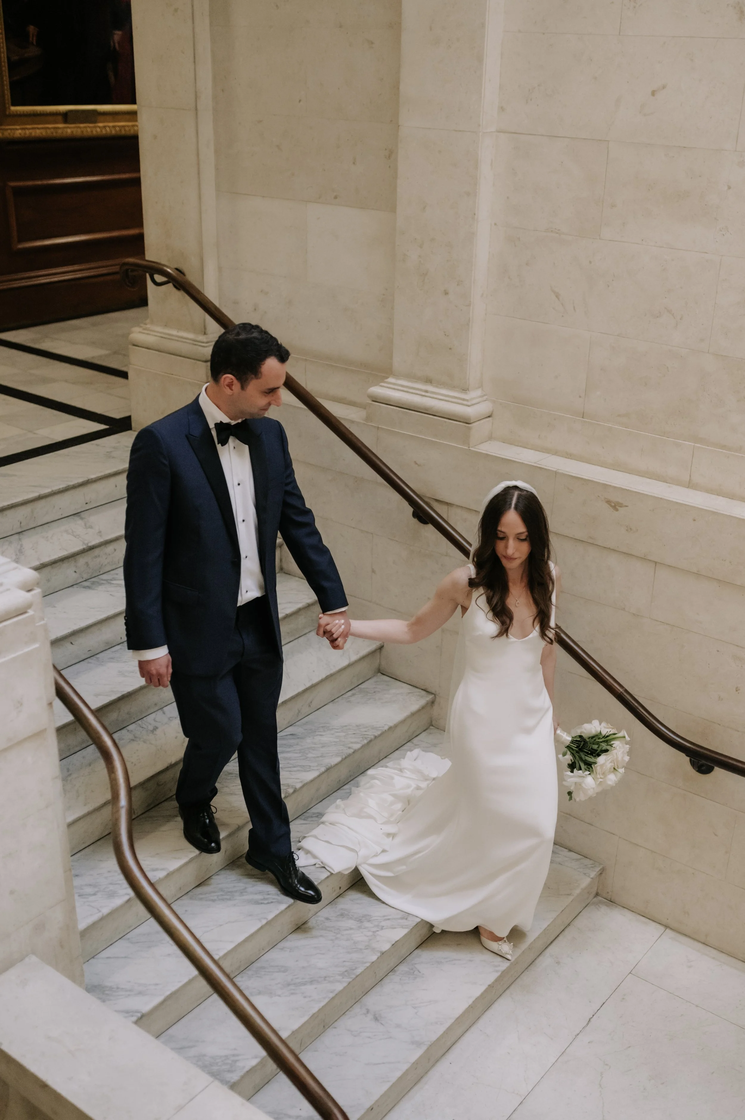 London wedding photography at Marylebone Town Hall bride and groom walking down stairs inside marylebone town hall 