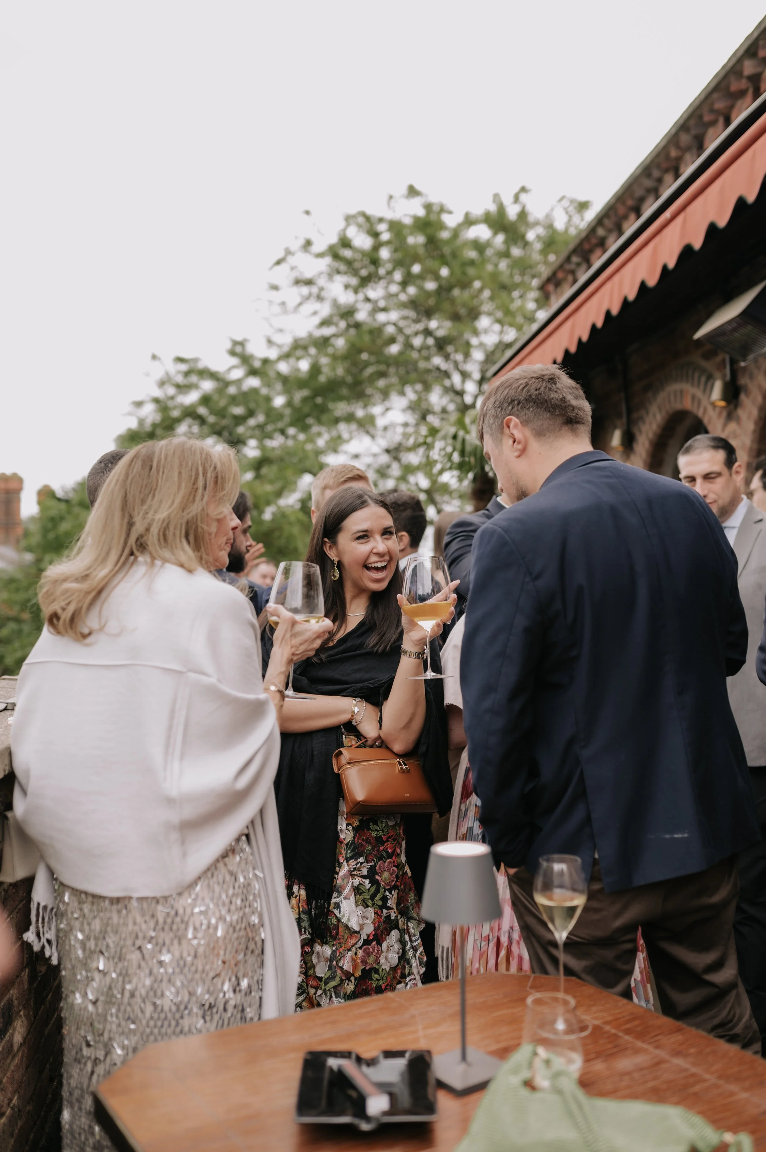 London wedding photography at Belvedere in Holland Park guest cheering drink to camera