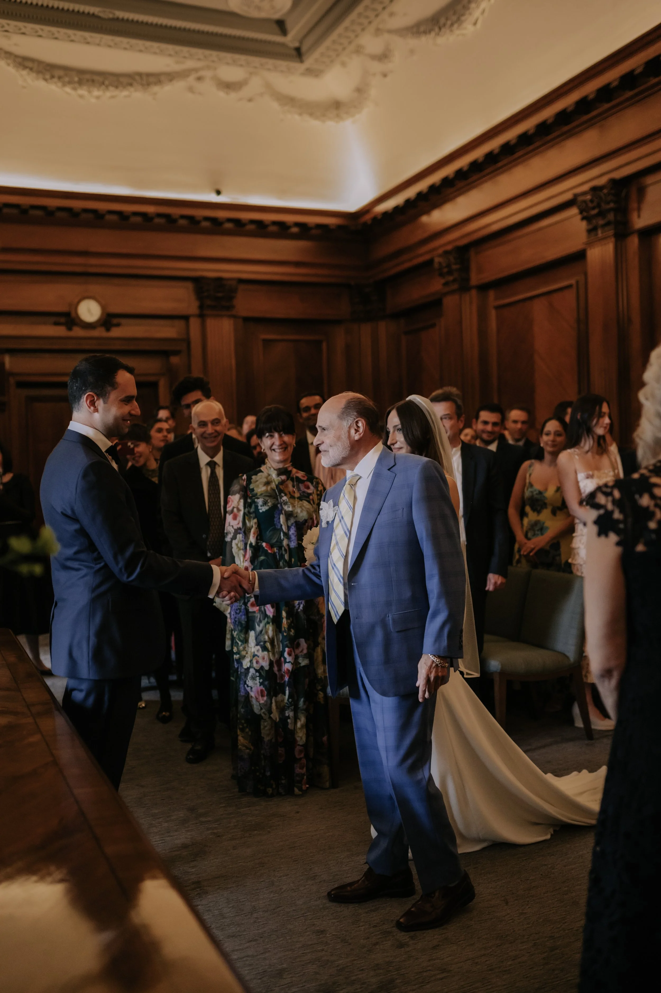 London wedding photography at Marylebone Town Hall bride's dad shaking hands with groom