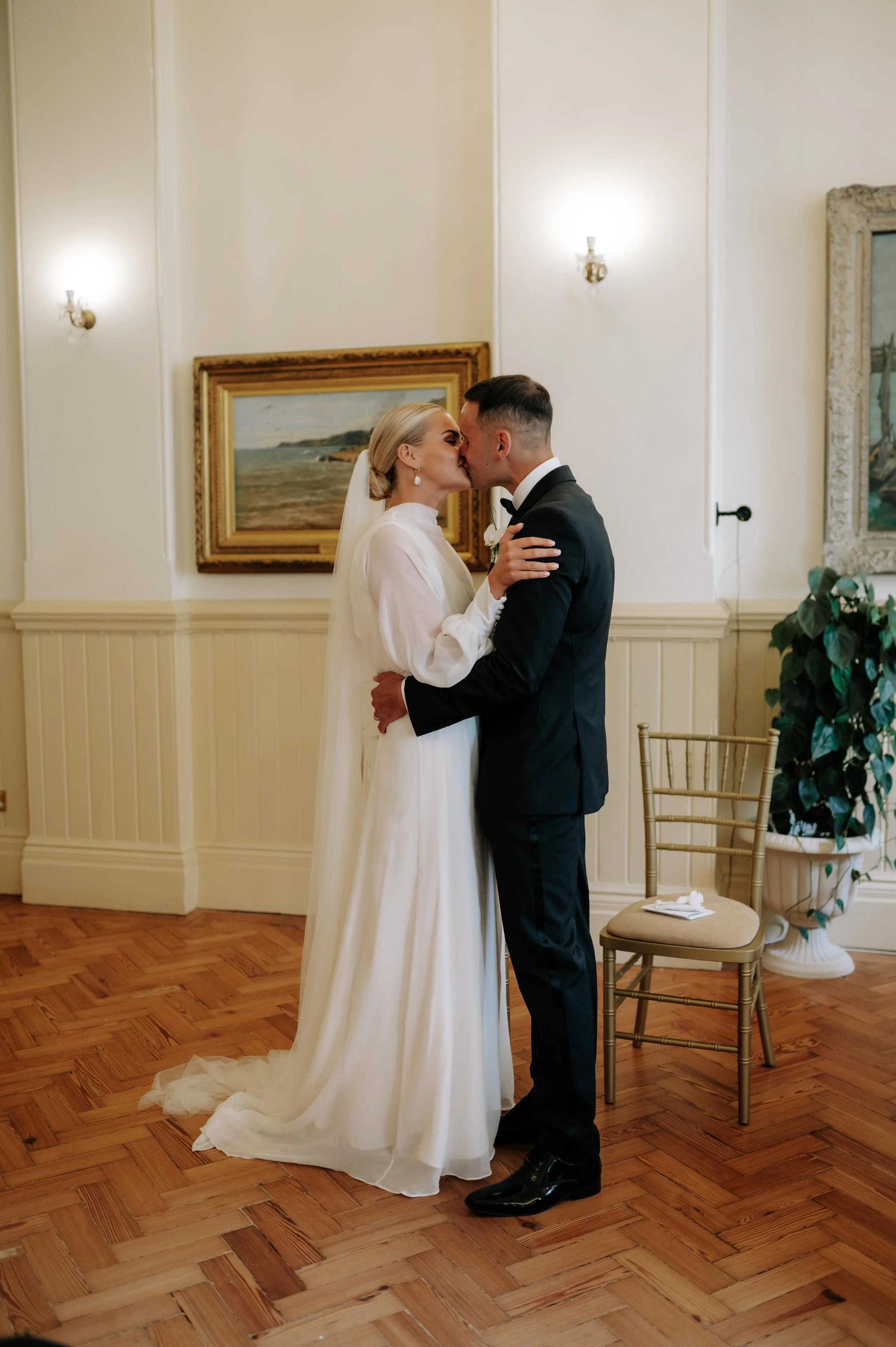 Bride and groom sharing first kiss at Brighton wedding. Fine art documentary wedding photography. 