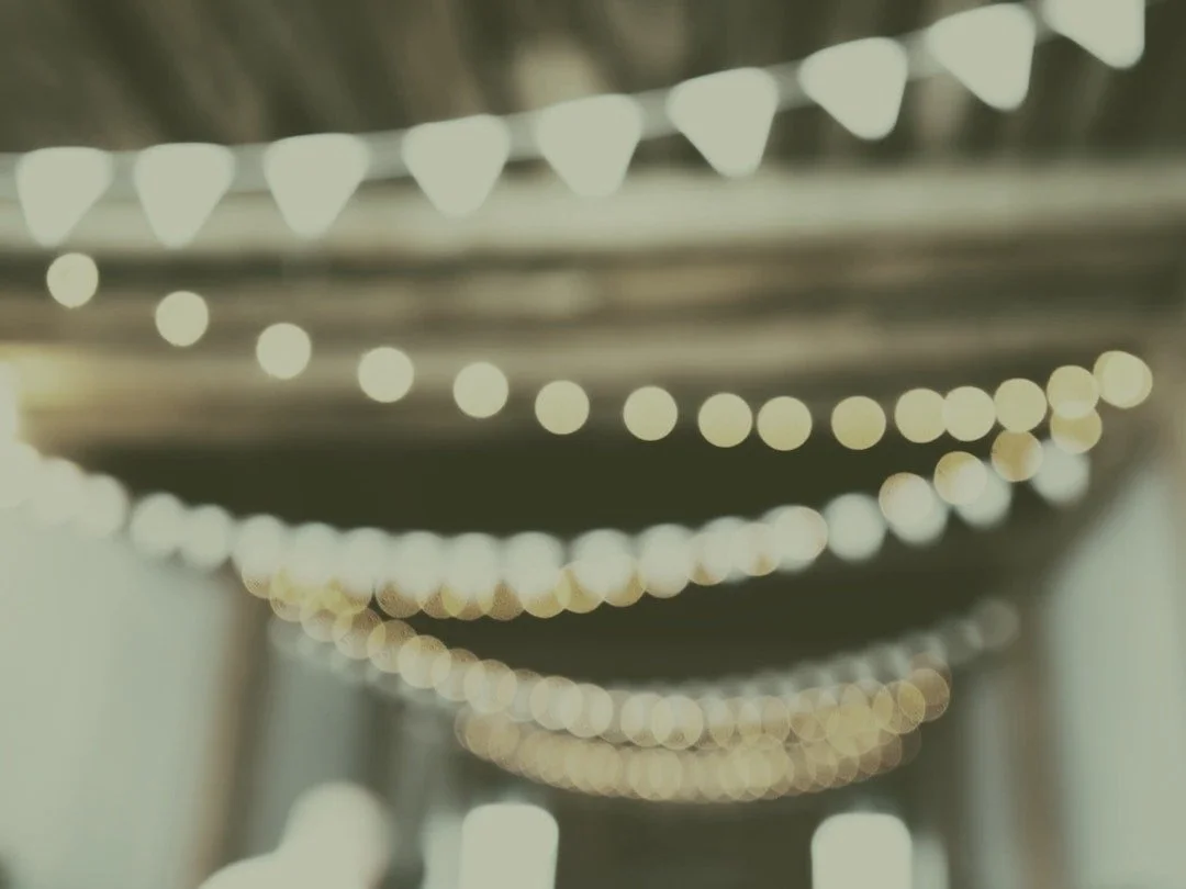 String lights and bunting glowing at an evening fundraising event venue