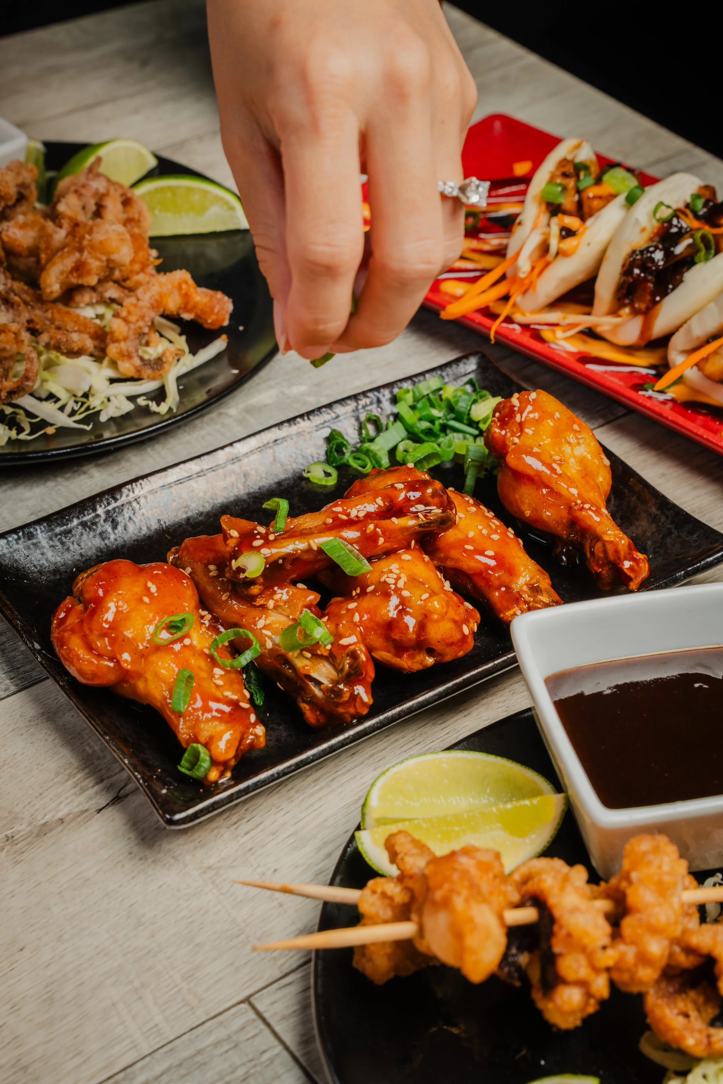 sprinkling green onions on chicken wings