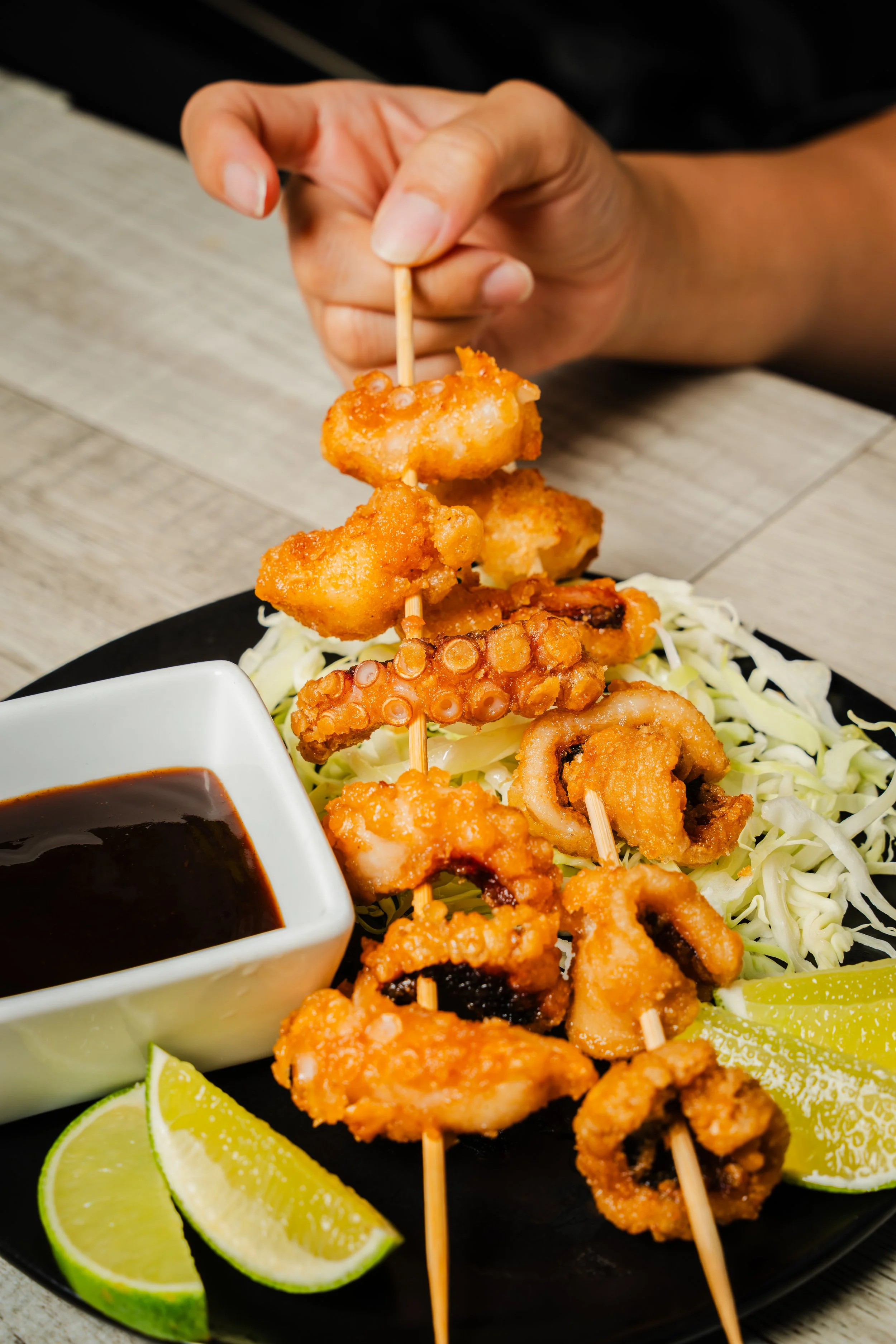 picking up squid skewers with hand
