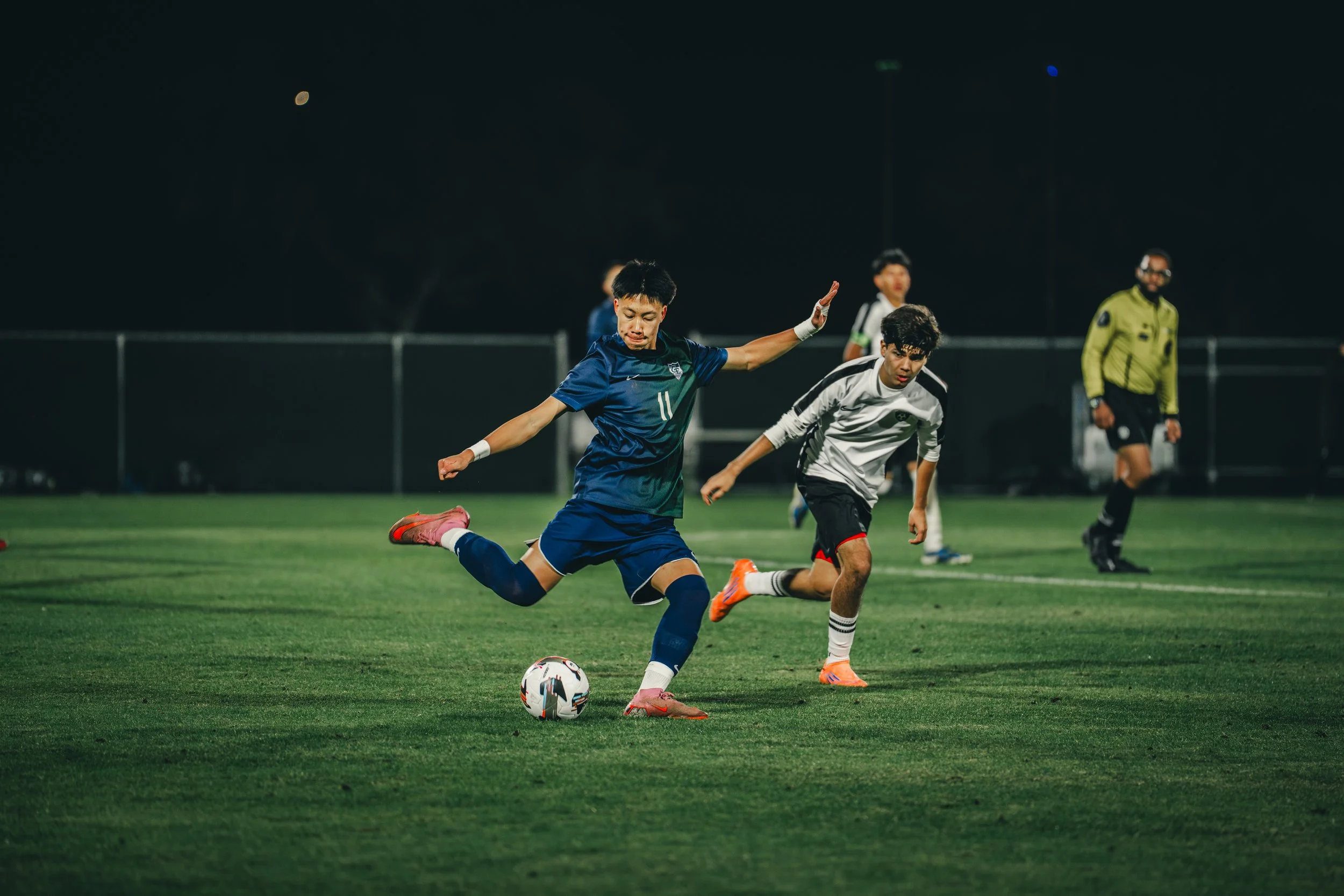 high school player kicking a soccer ball