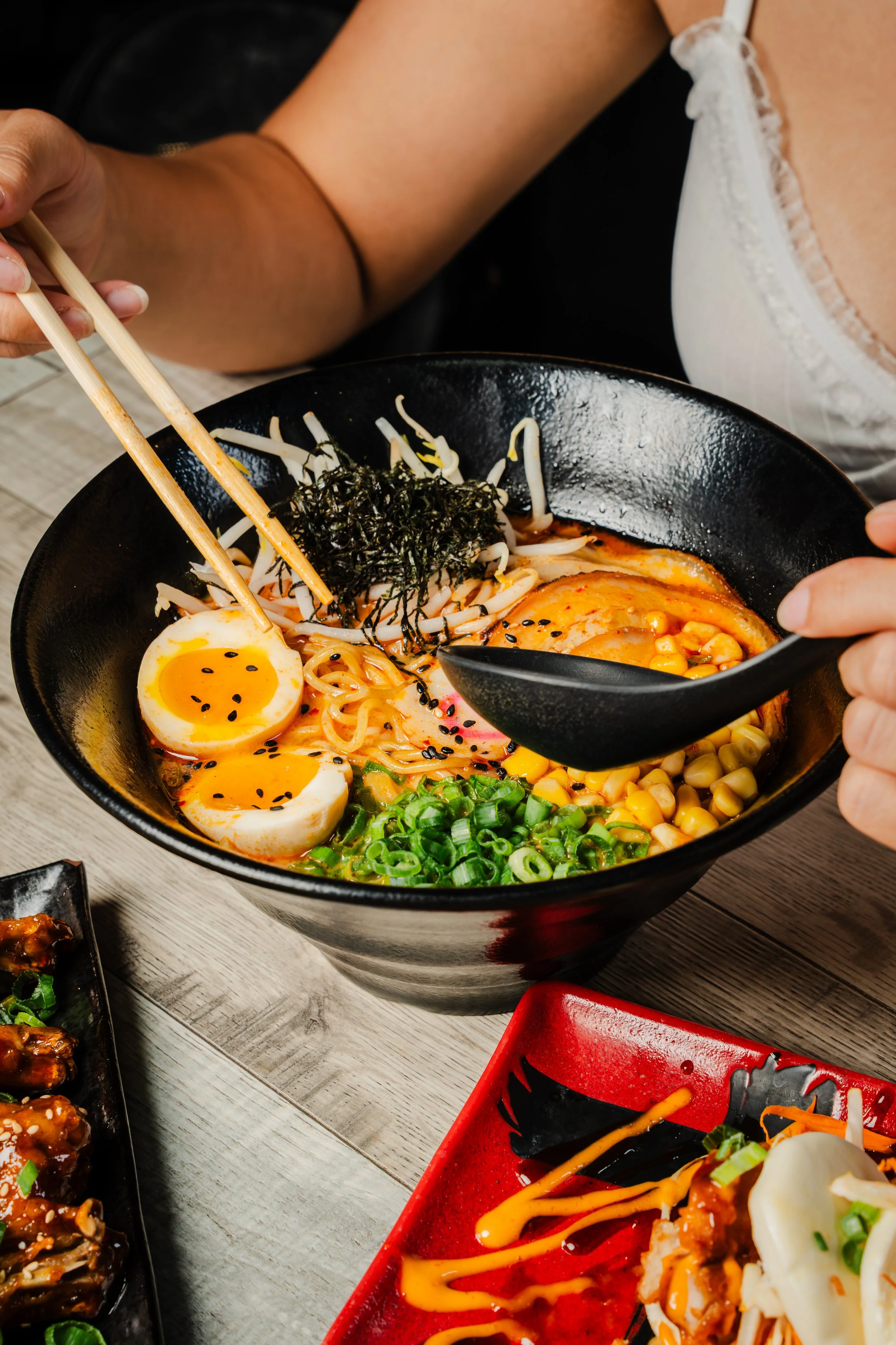 a person eating spicy tonkutsu ramen