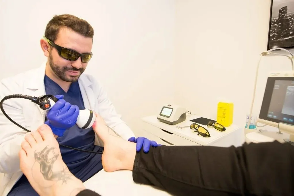 Médecin utilisant un appareil médical sur un pied, avec un patient à l'hôpital