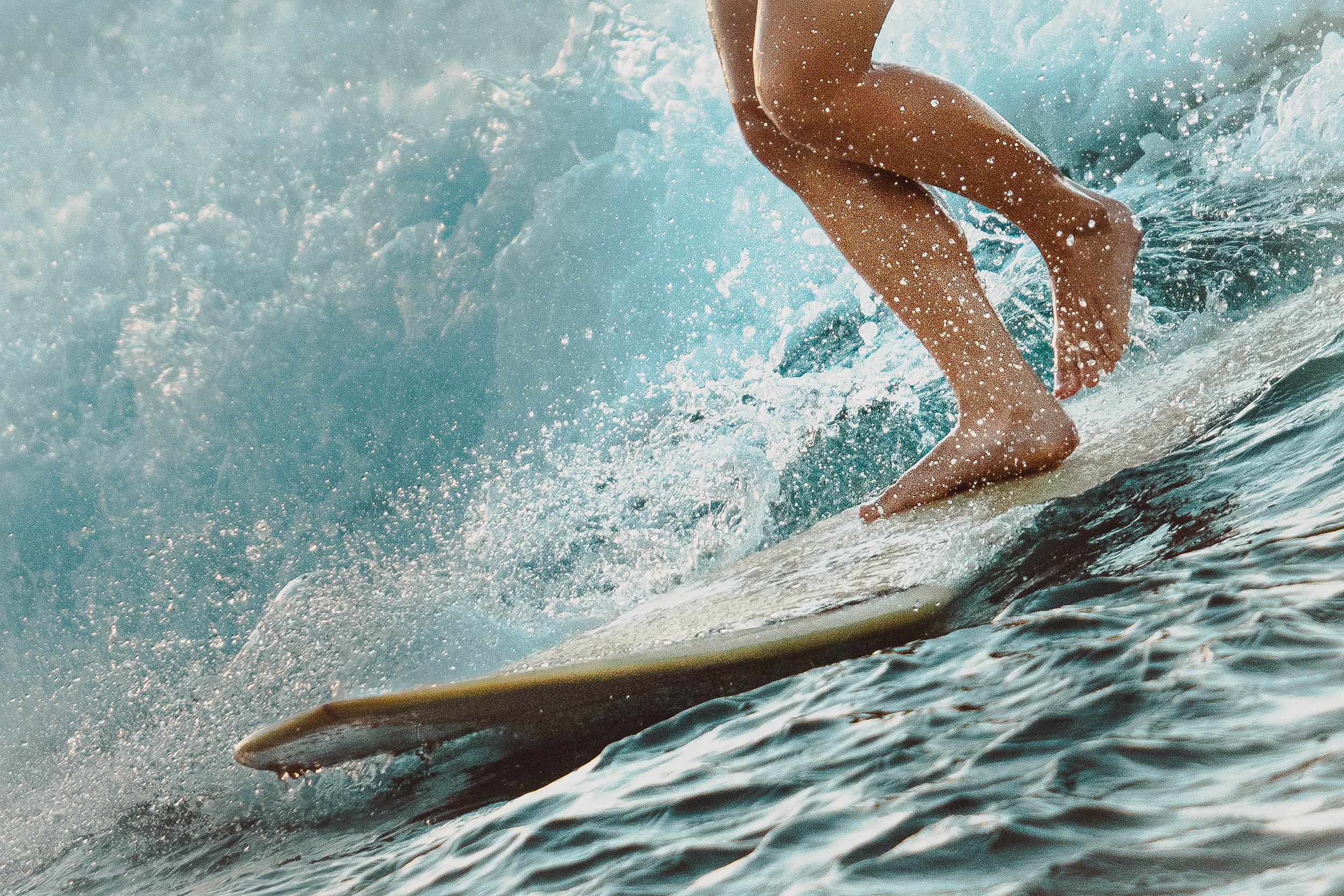 Person riding a surfboard on a wave in the ocean.