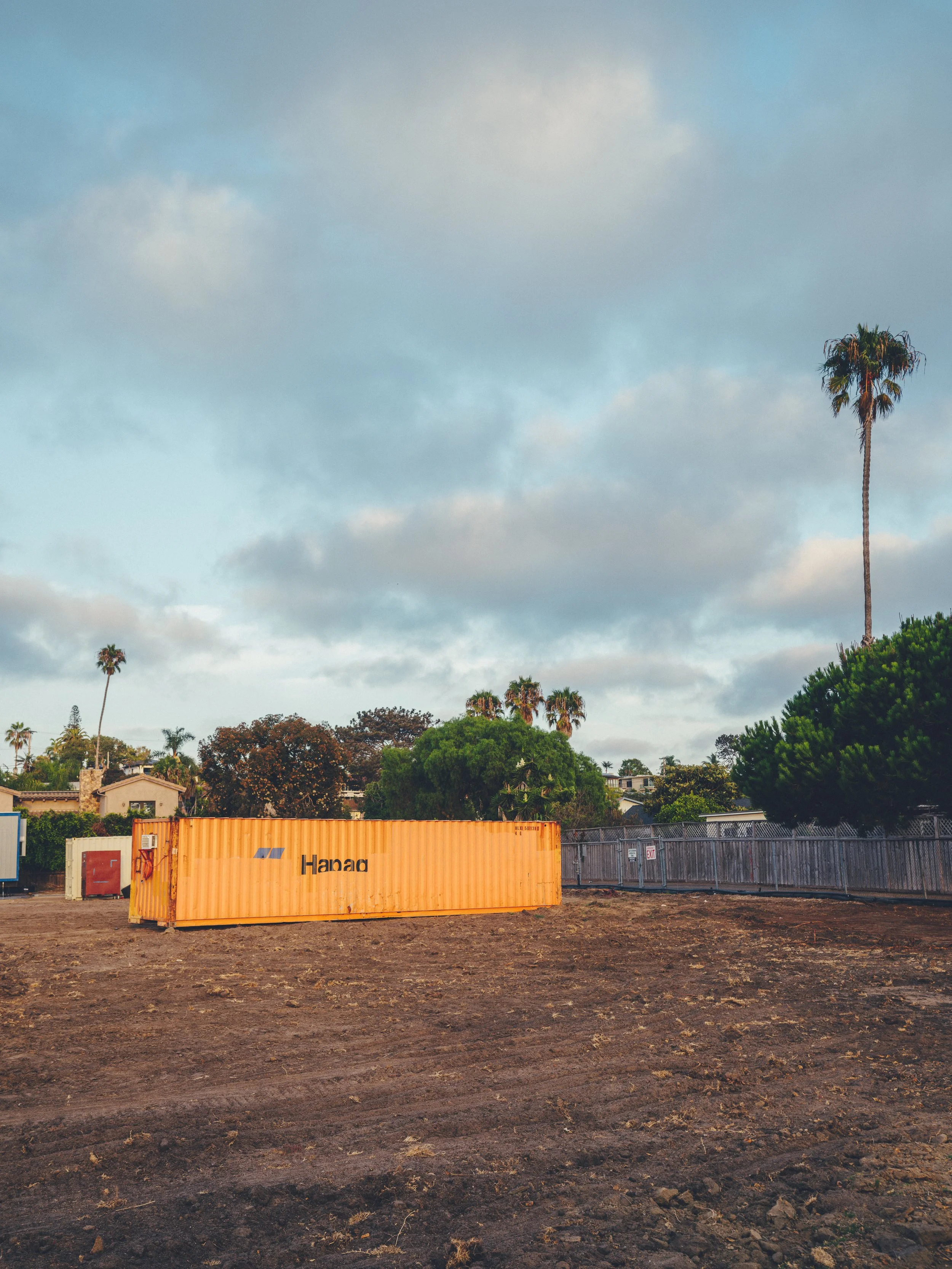 California coastal scene of large shipping container on a empty field in a neighborhood