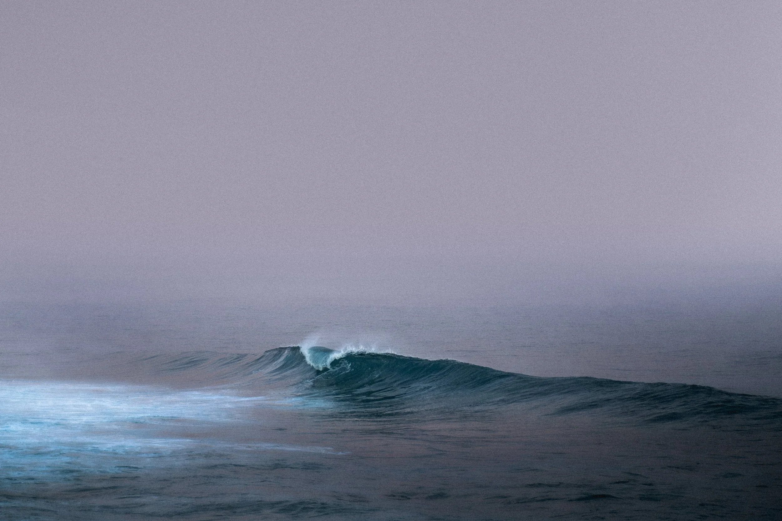 Overcast sky with ocean waves in the foreground, no people or objects visible.