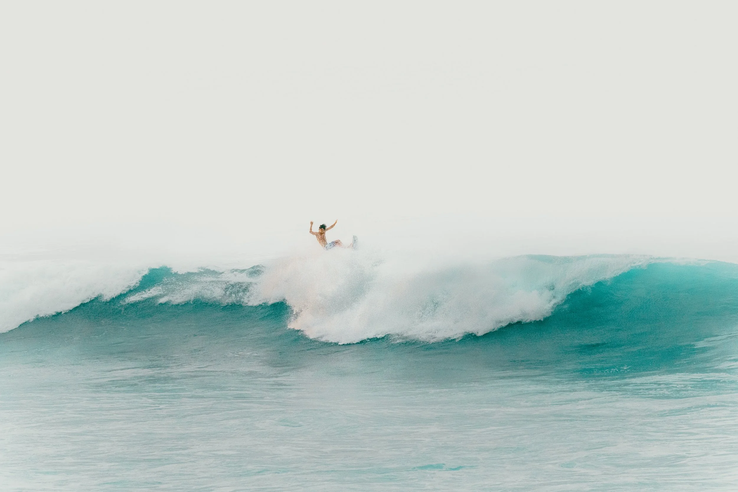 A person surfing on a wave in the ocean.