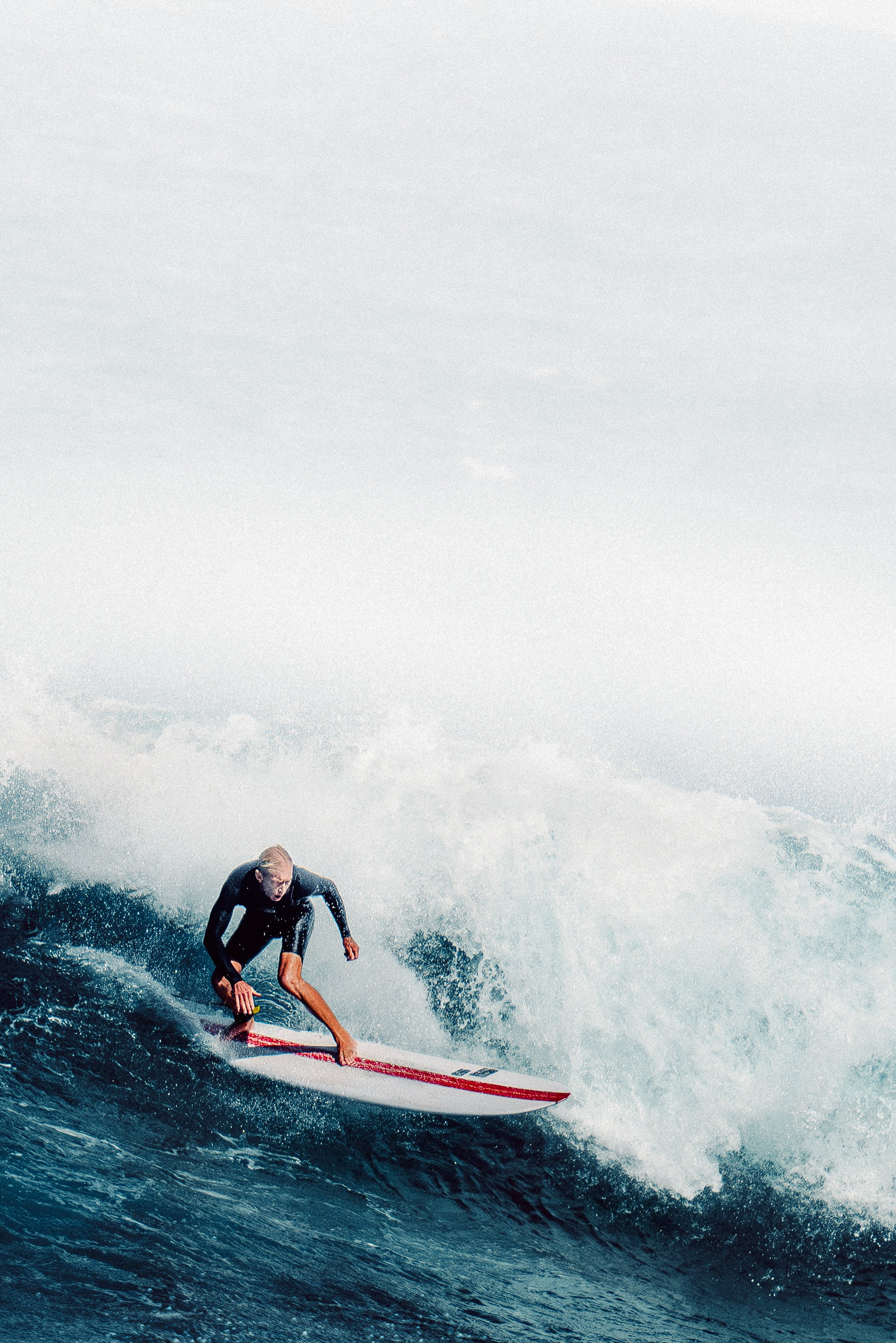 Person surfing on a wave in the ocean.
