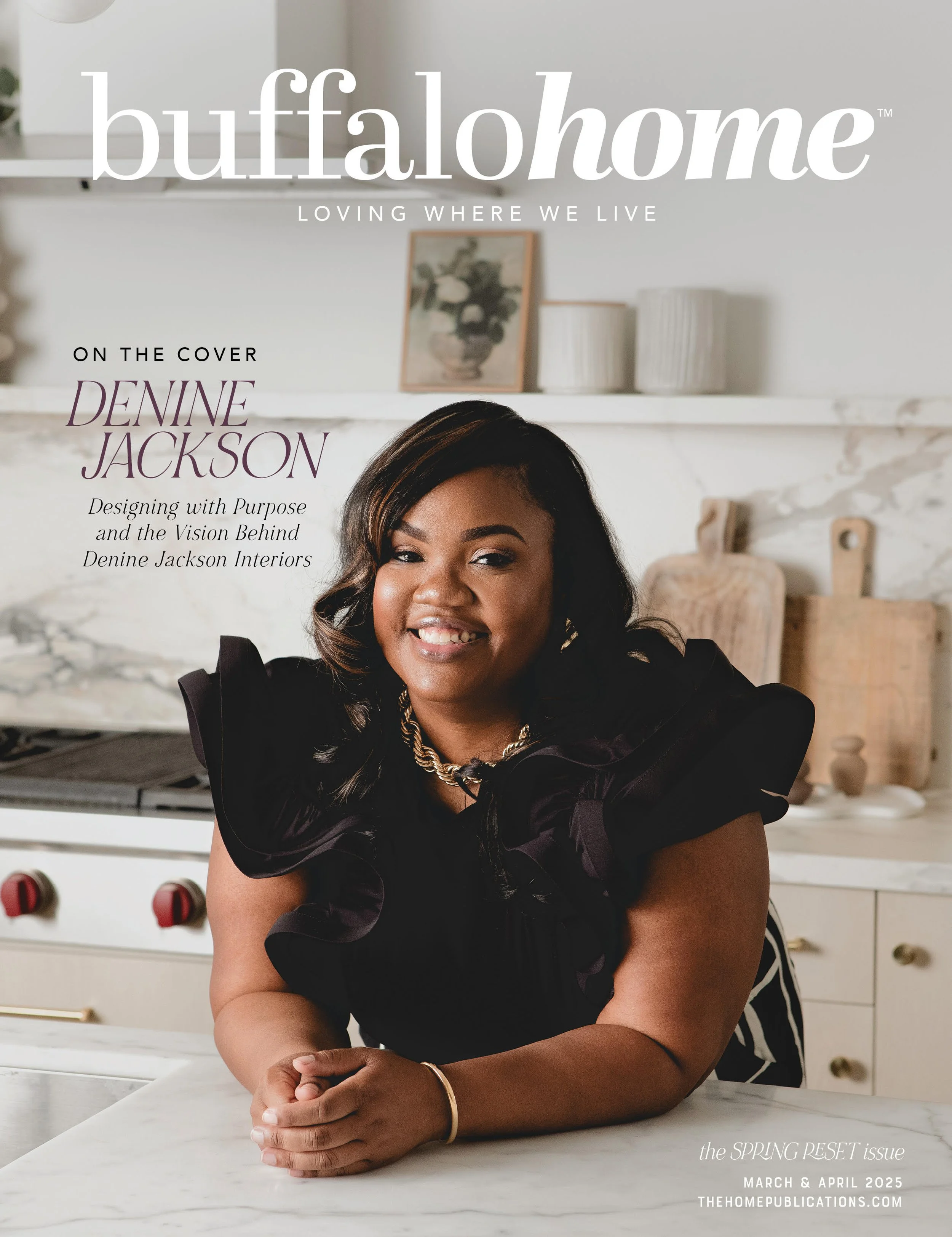 Cover of Buffalo Home magazine featuring a woman with dark hair and a warm smile, sitting at a white marble kitchen countertop, with a white stove and kitchen decor in the background. The magazine is titled 'buffalo home', with the subtitle 'LOVING WHERE WE LIVE' and a feature on Denine Jackson, 'Designing with Purpose and the Vision Behind Denine Jackson Interiors,' for the March and April 2025 issue.