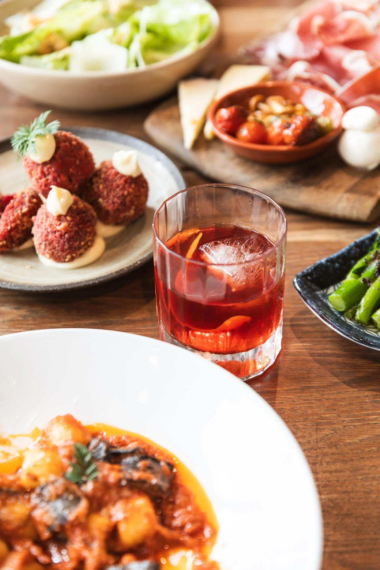 A table with various Italian dishes, cocktails, wine at a relaxed, casual local Italian restaurant located just off Main Street, Mornington