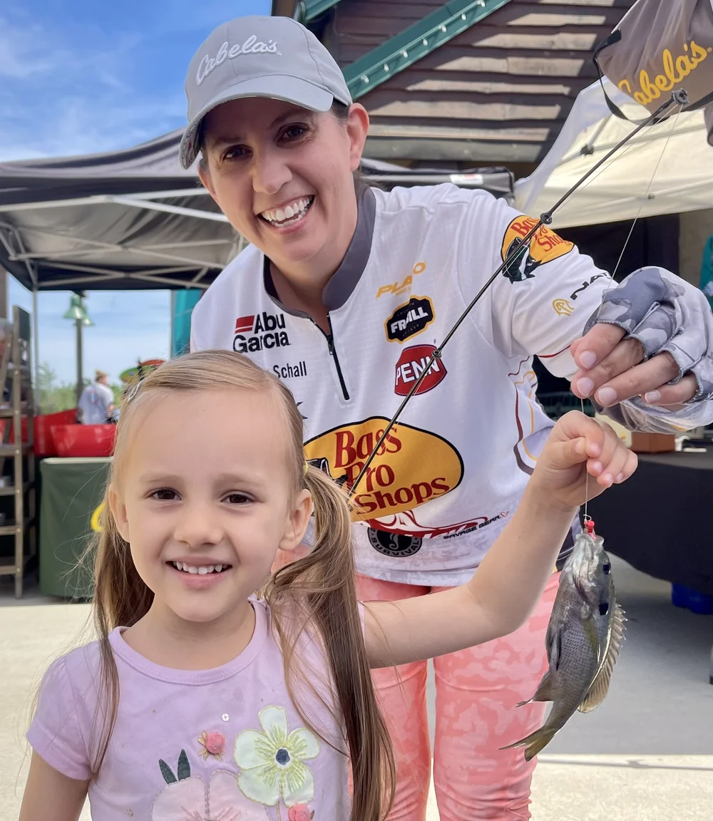 Jennifer assisting a young lady with her first fish during a recent fishing clinic.