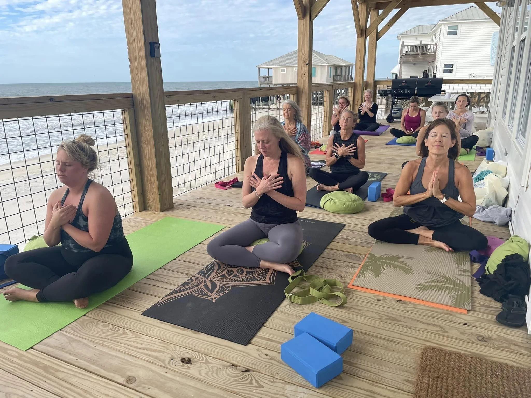 Students take a moment to connect and center during their practice at the beach.