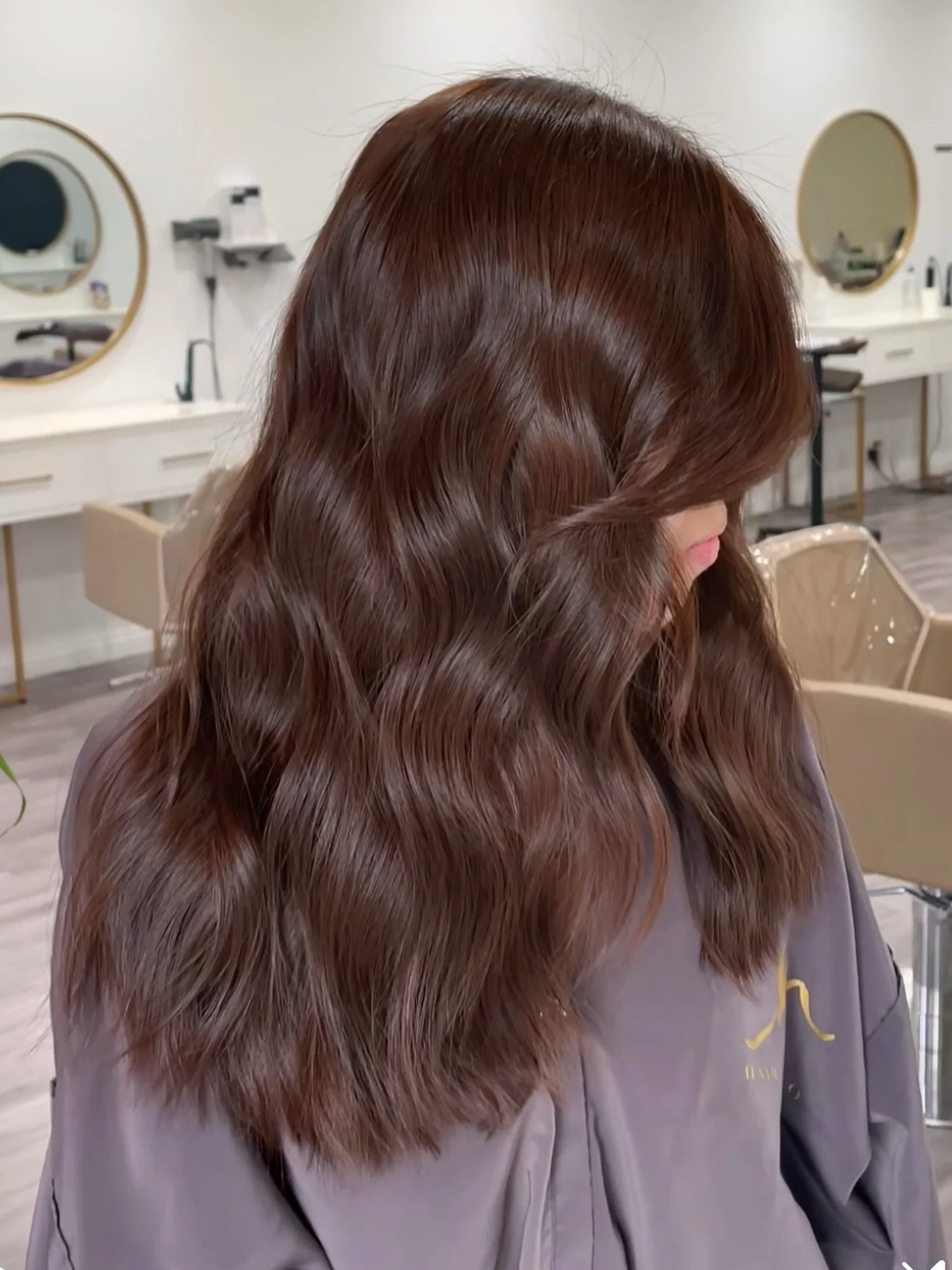 Rich chocolate brown tones and styled with beautiful  shiny waves that turn heads, created by @styledby_katpena. 

Ready to fall in love with your hair again? ✨

For appointments please reach out via our website. General information, service menu, pr
