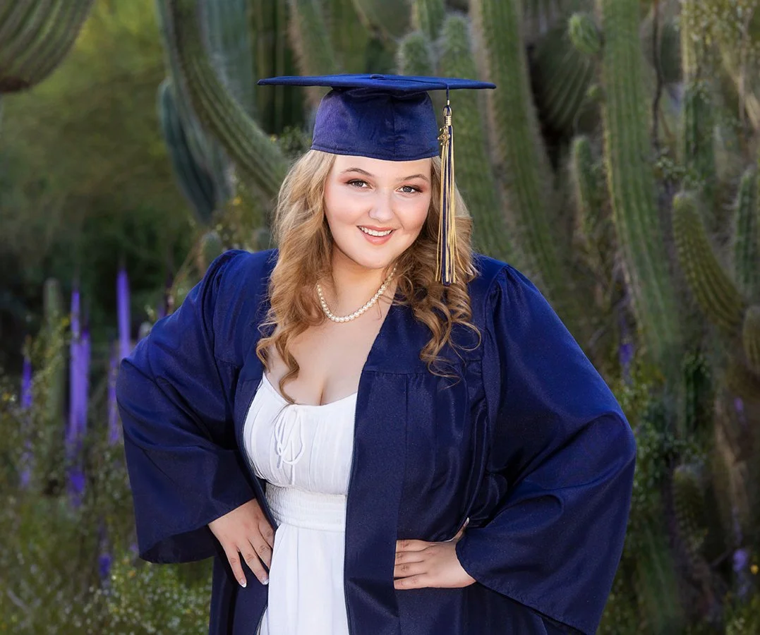 High School Senior. Young woman in a graduation cap and gown smiling outdoors with cacti in the background. Desert Botanical Gardens. Phoenix.
