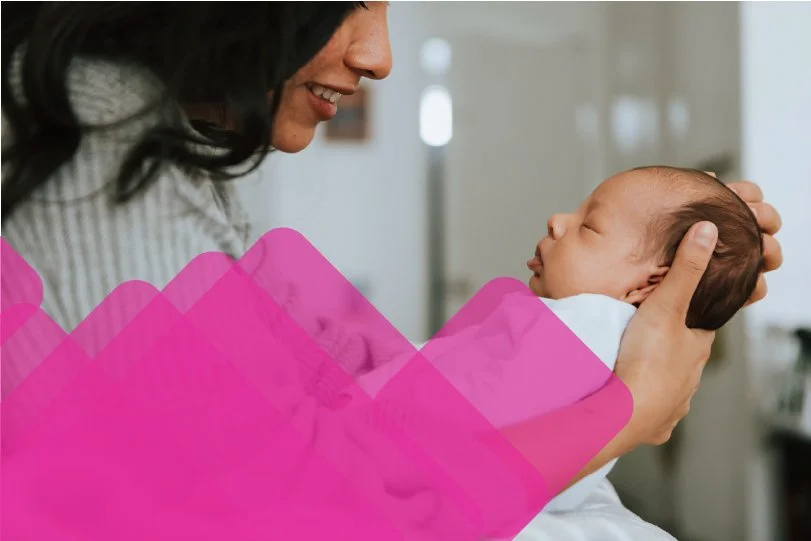A woman closely holding an infant.