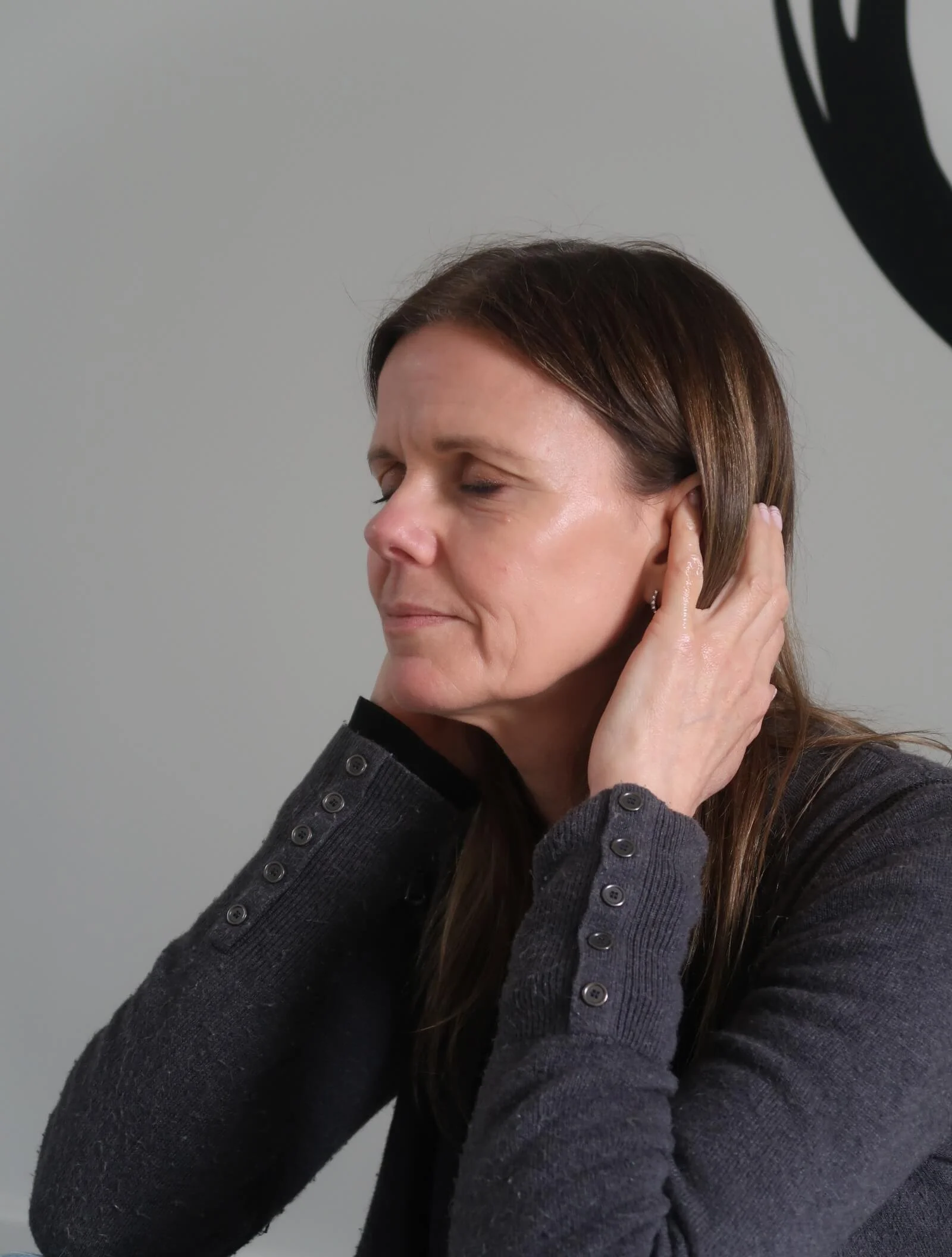 Helen Mercercox with hands next to her ears at essential oil experience at Nature at Work team day workshop