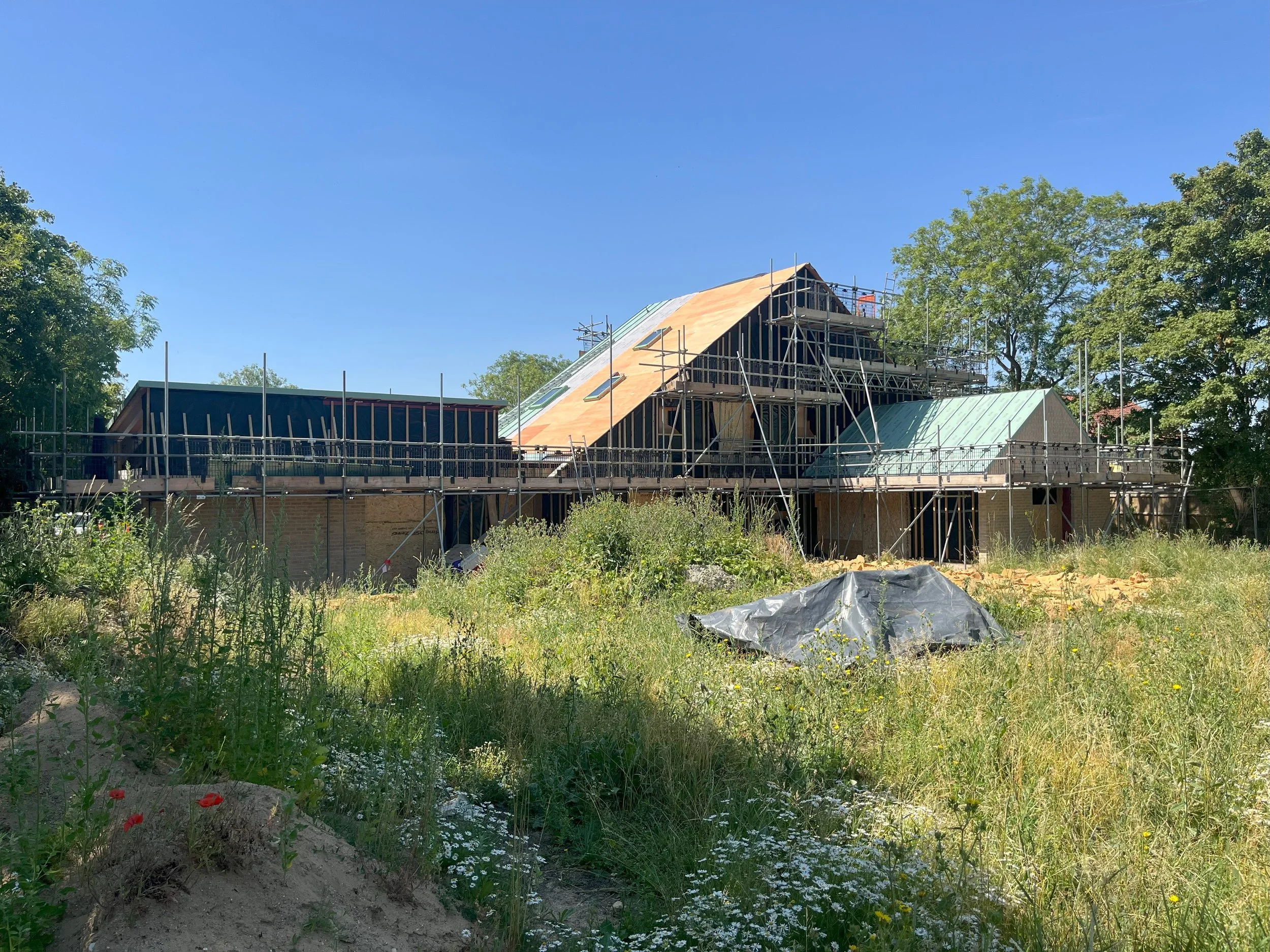 Hereward House Passive House under construction in Aldreth Cambridgeshire with timber frame structure and wildflower landscape foreground