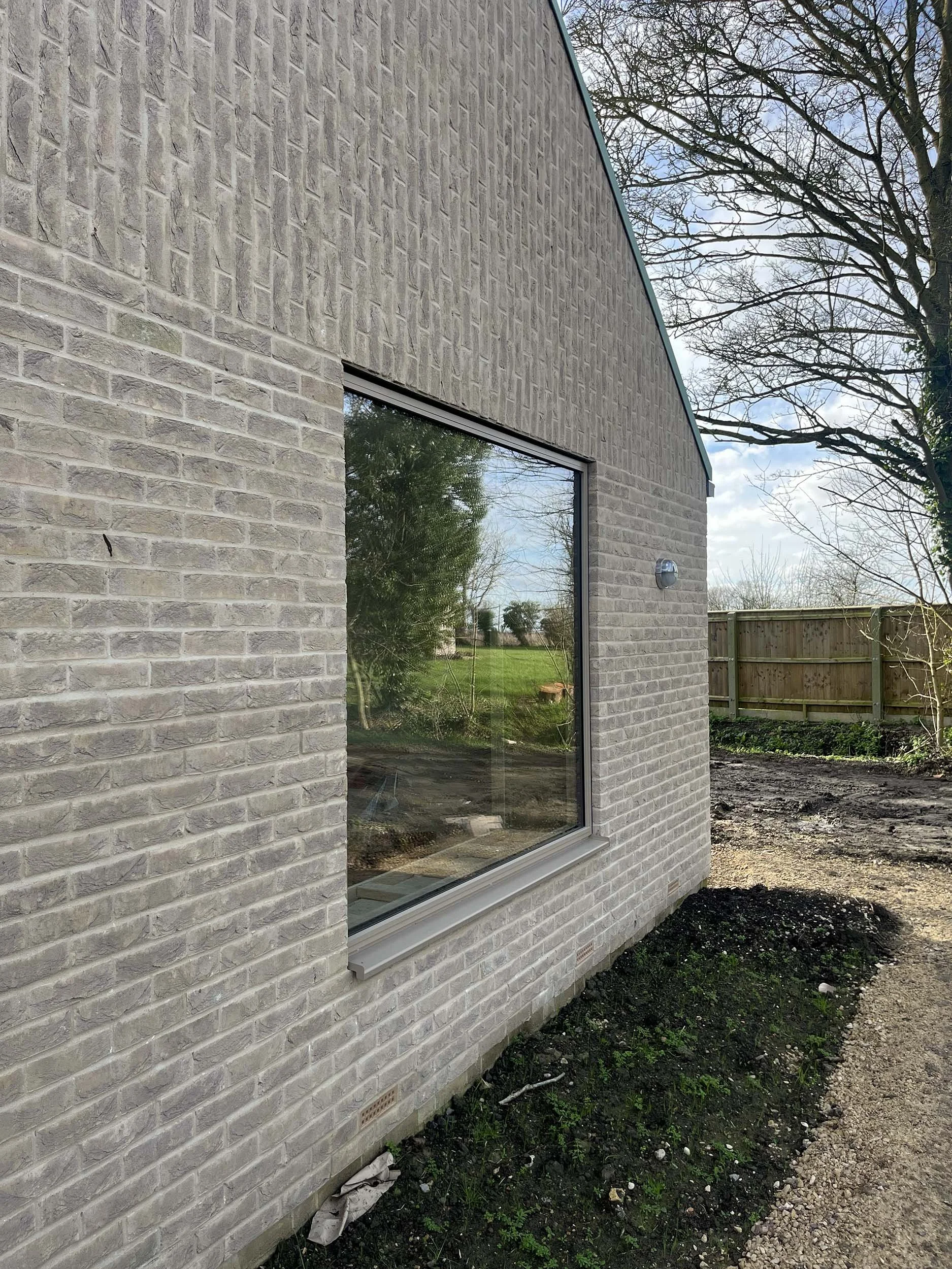 Hereward House – Brick and timber-clad side elevation of  Passive House in Aldreth, Ely, Cambridgeshire