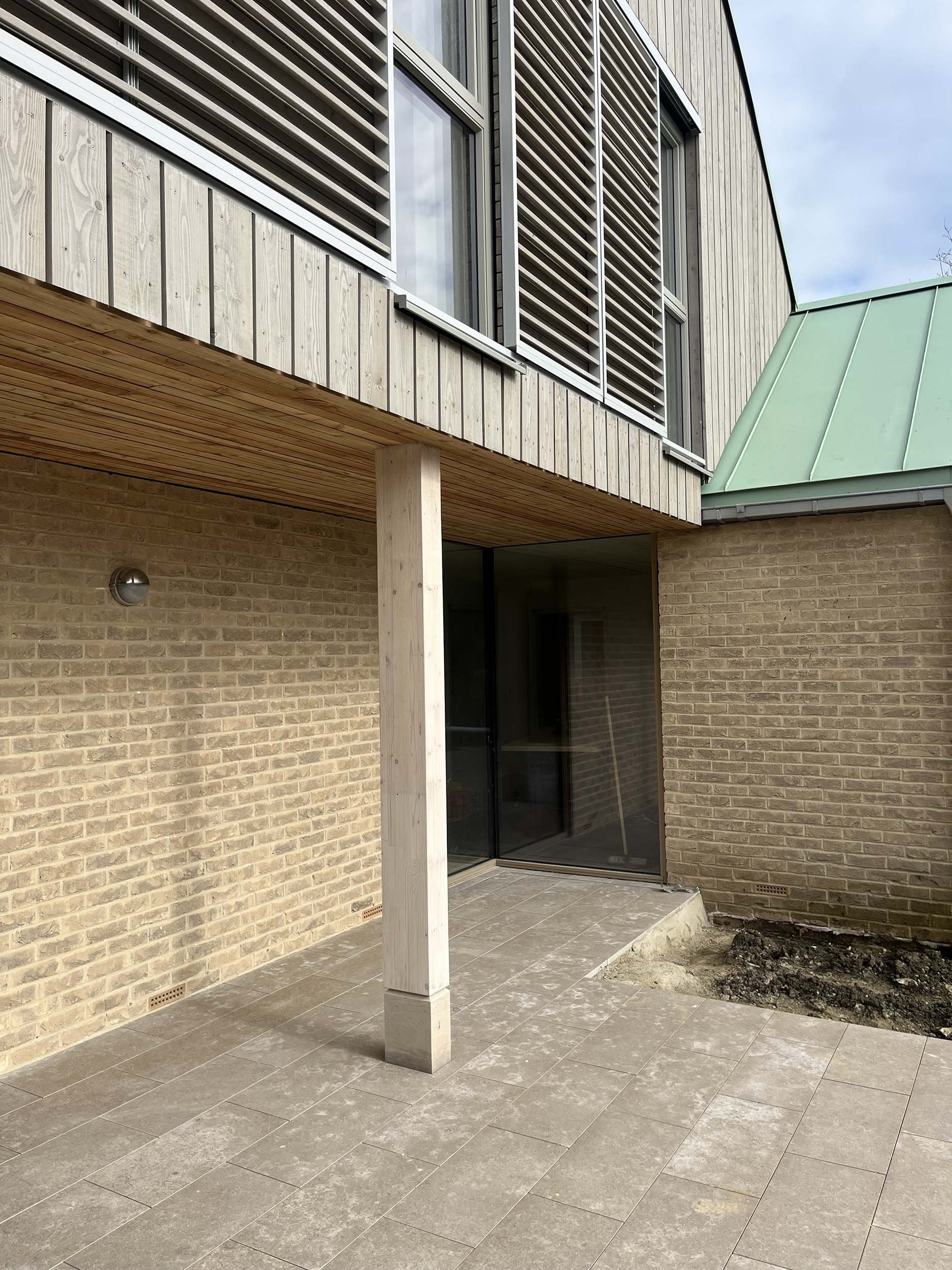 Hereward House – Timber-clad covered courtyard walkway with brick and glazed detailing in Aldreth, Ely, Cambridgeshire