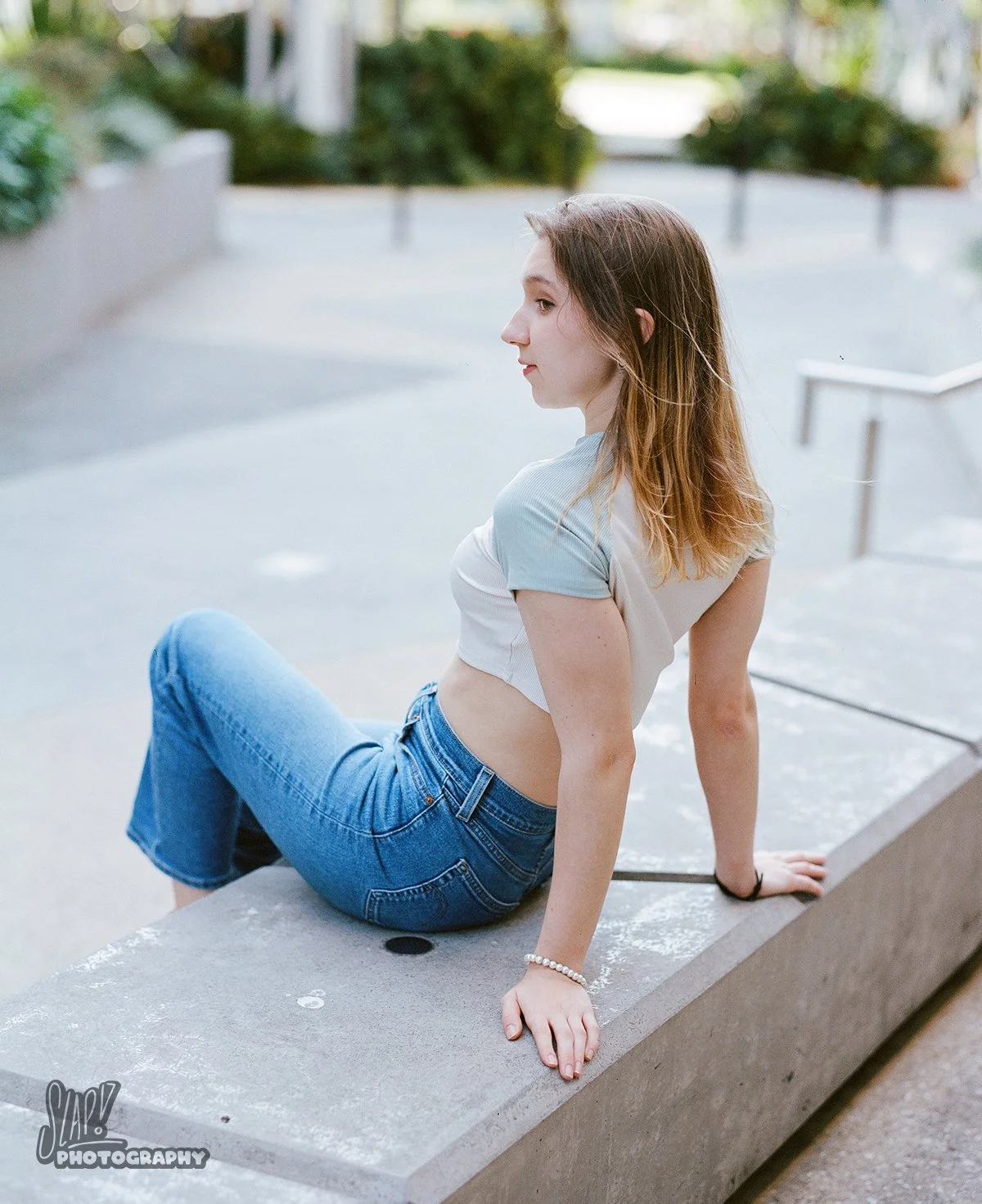 Pretty girl in blue jeans sitting in urban environment