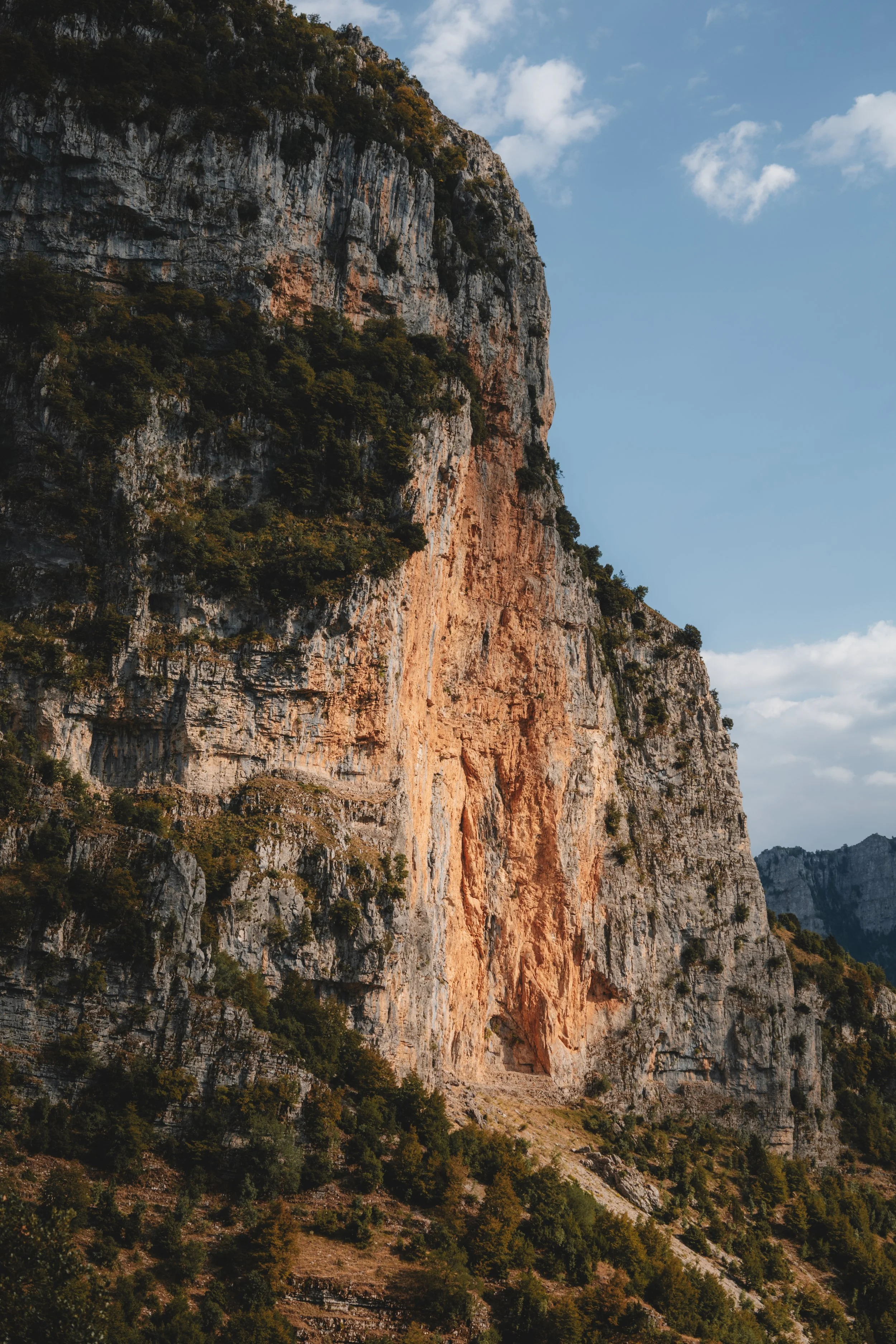 The stunning red cliff of « Κοκκινολιθάρι» or 'Red Rock.' Part of the 'Papingo Towers,' the west facing cliffs of the Astraka Massif that overlooks the villages of Mikro and Megan Papingo in the Zagori mountains of northern Greece.