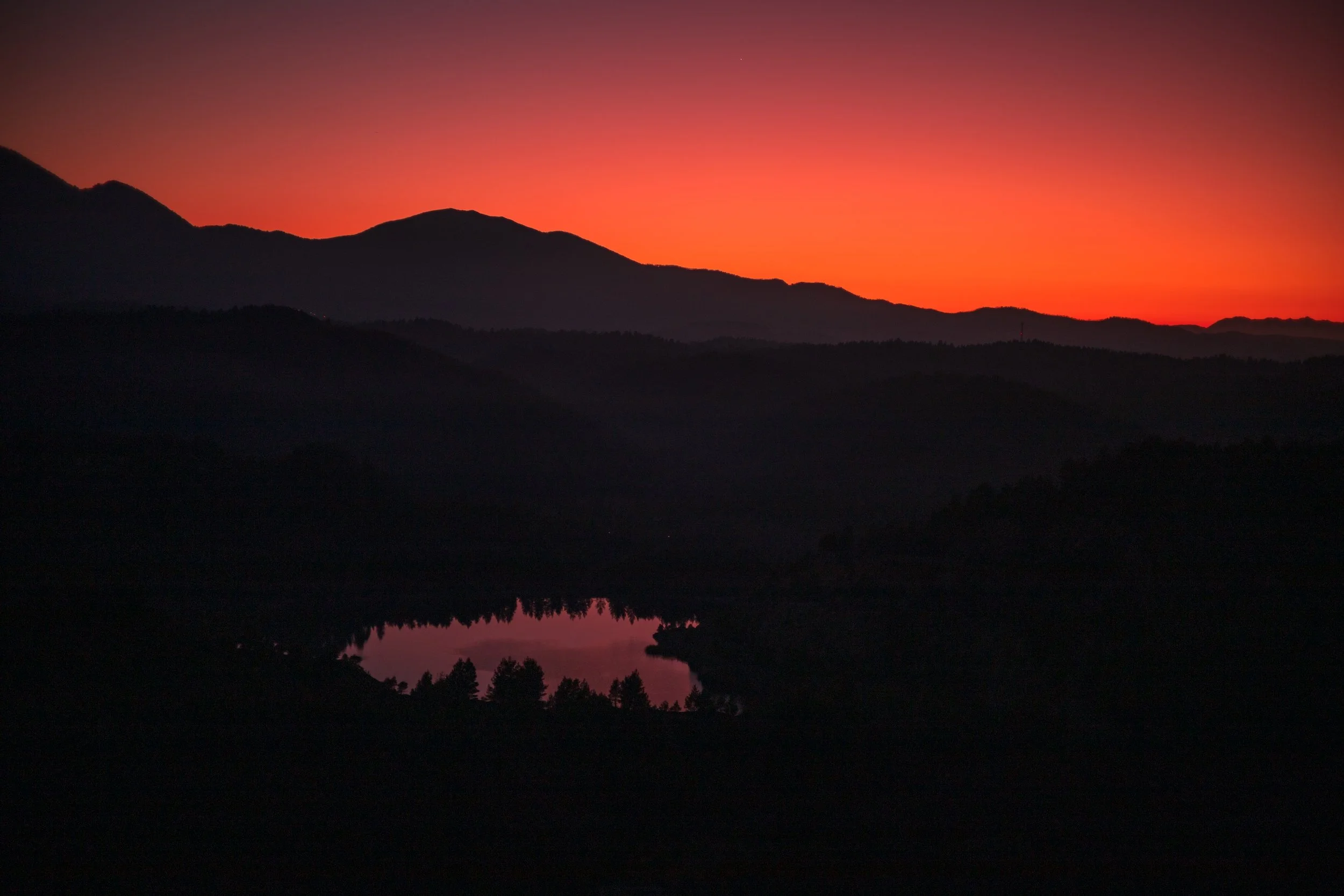 Wild landscapes. A lake reflects the deep orange post sunset hues, Evia, 2023.