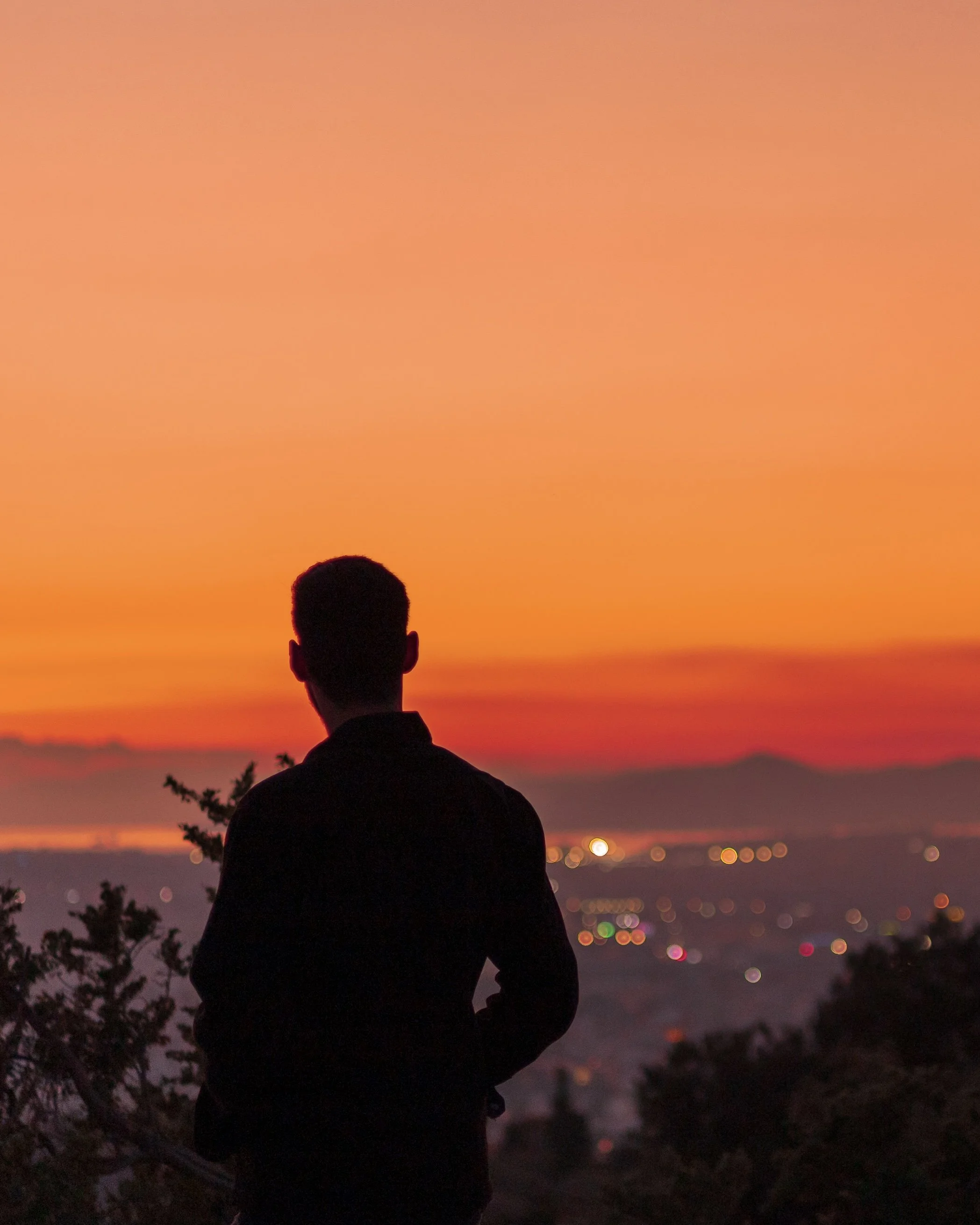 Sunset silhouette. Admiring the colours and the city lights stretching south towards Piraeus. Filopappou hill, Athens, NYE 2022.