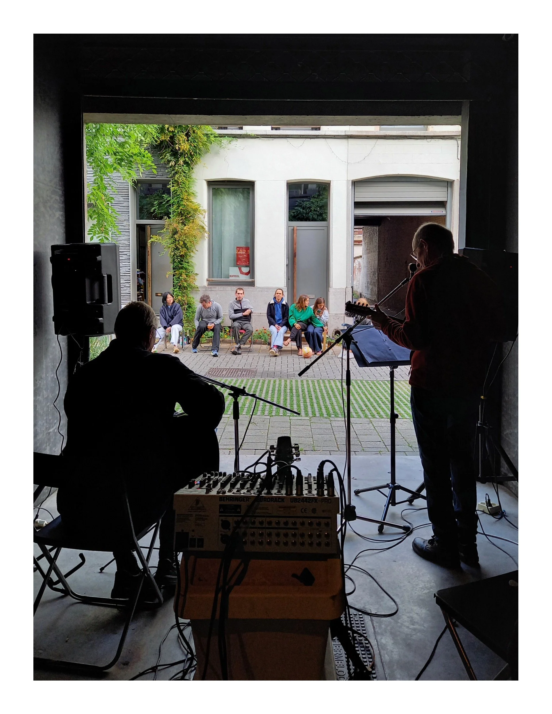 Muzikanten spelen binnen terwijl mensen buiten luisteren.