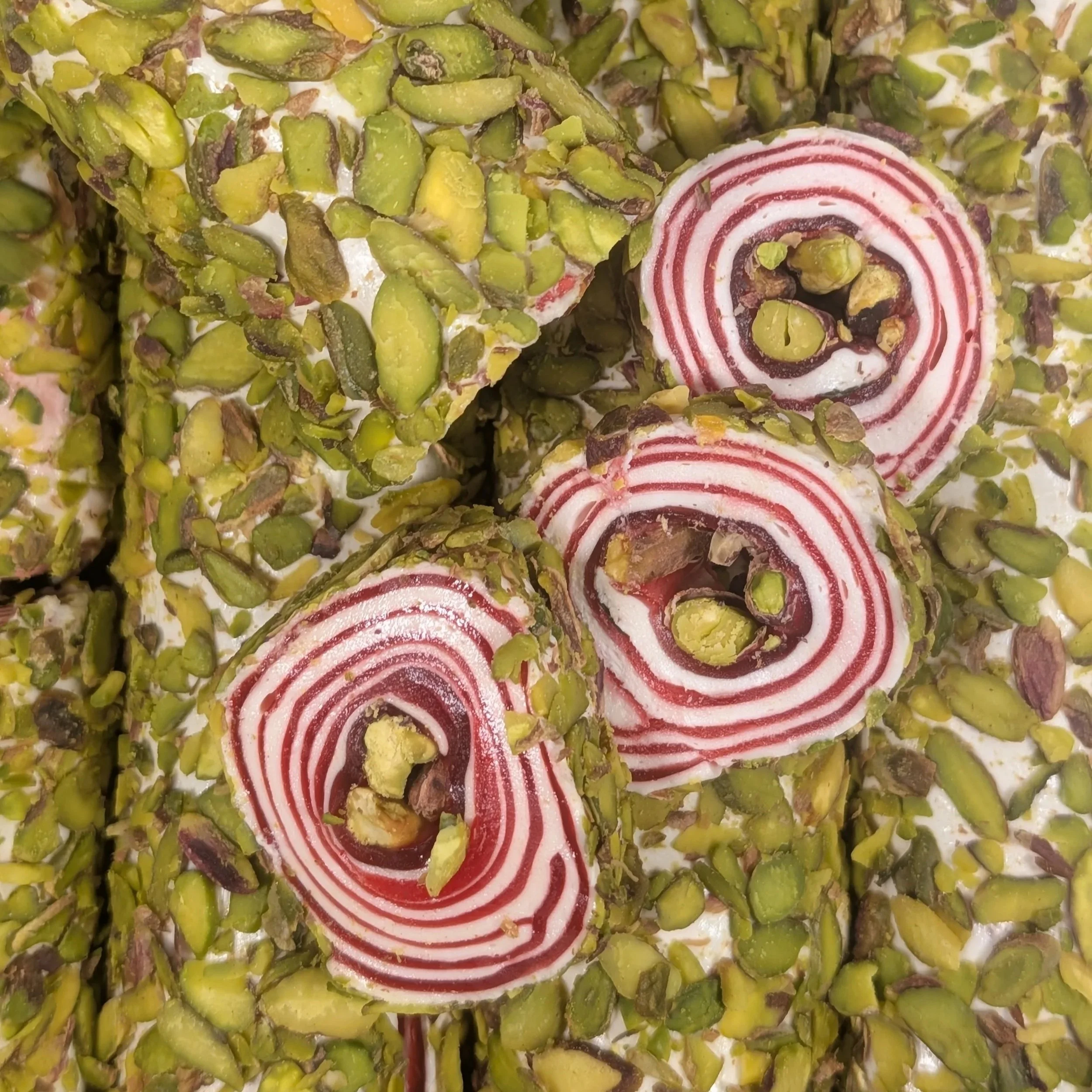 The intricate spiral craftsmanship of our signature Pomegranate and Pistachio Turkish Delight Roll.