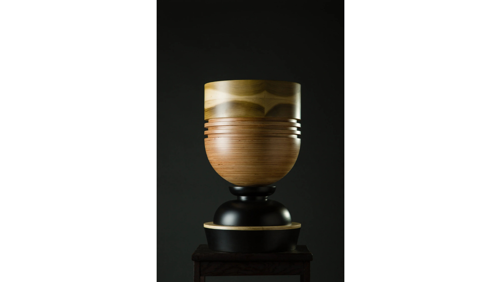 A sculptural vessel that forms a part of the Tropical Noire collection by artist, Simone Brewster. The sculpture is made of carved timber wood, drawing on African cereminal forms. Hand-crafted wood sculpture.