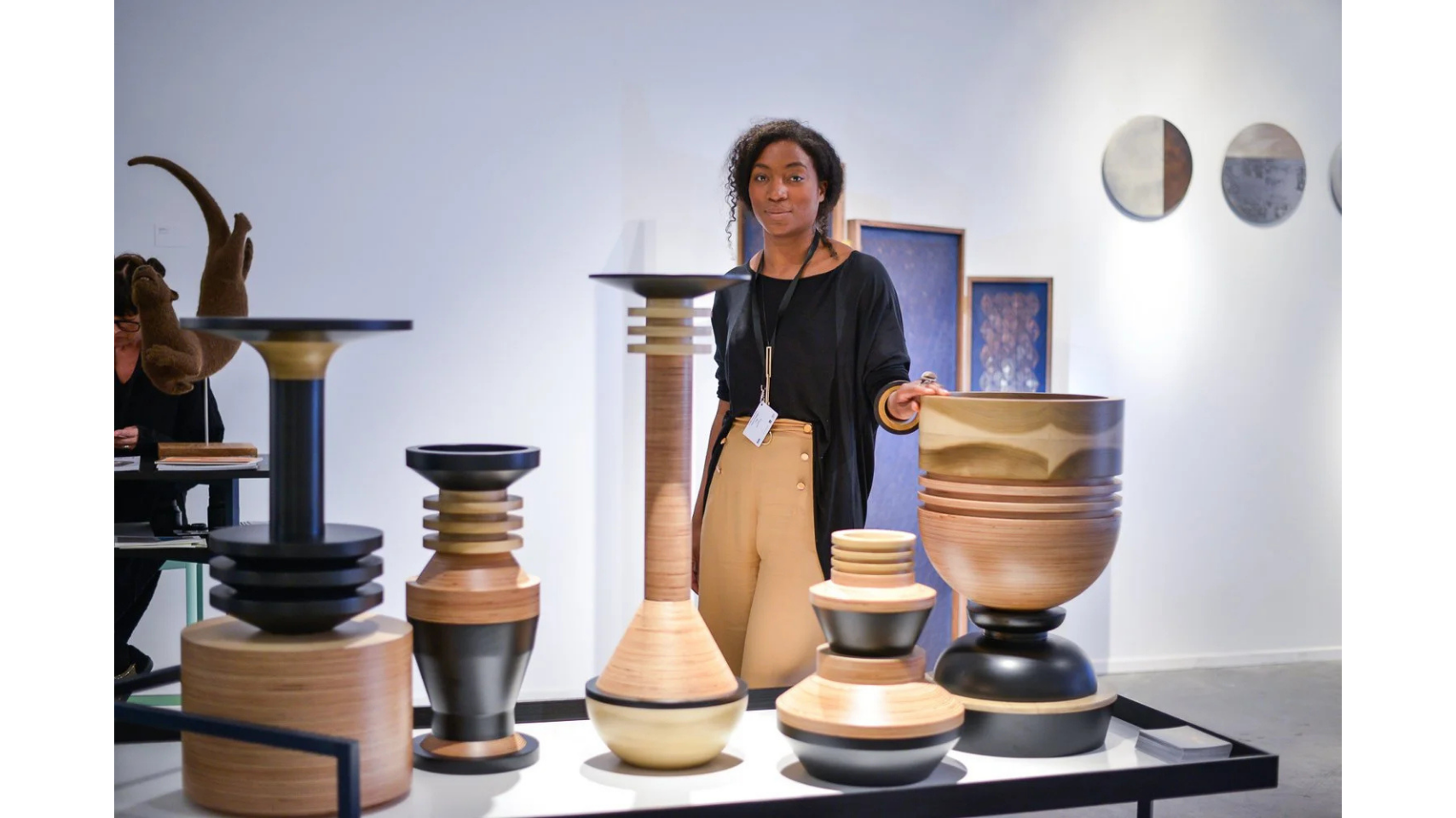 Artist Simone Brewster with her sculptural vessel that form the Tropical Noire collection. The sculptures are made of carved timber wood, drawing on African cereminal forms. Hand-crafted wood sculptures.