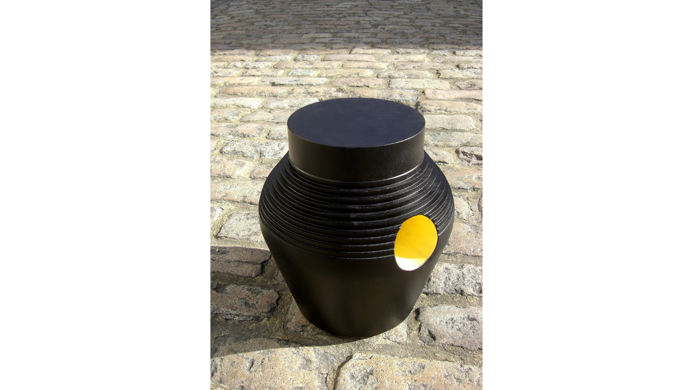 Carved stool crafted from solid ebonised tulipwood, with a hole on the side painted yellow