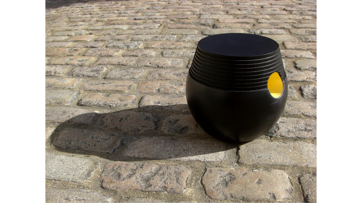 Carved stool crafted from solid ebonised tulipwood, with a hole on the side painted yellow