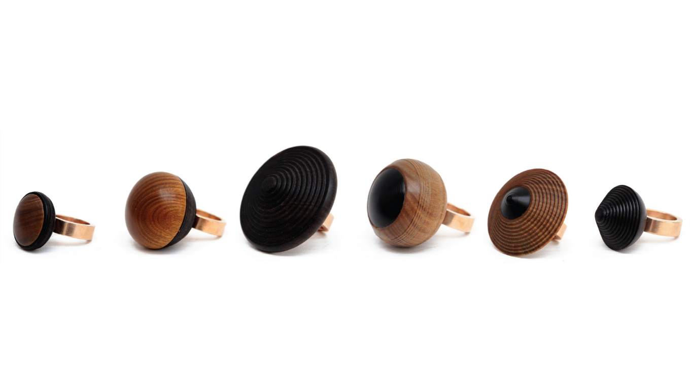 A line of six handmade rings made by Simone Brewster crafted out of wood