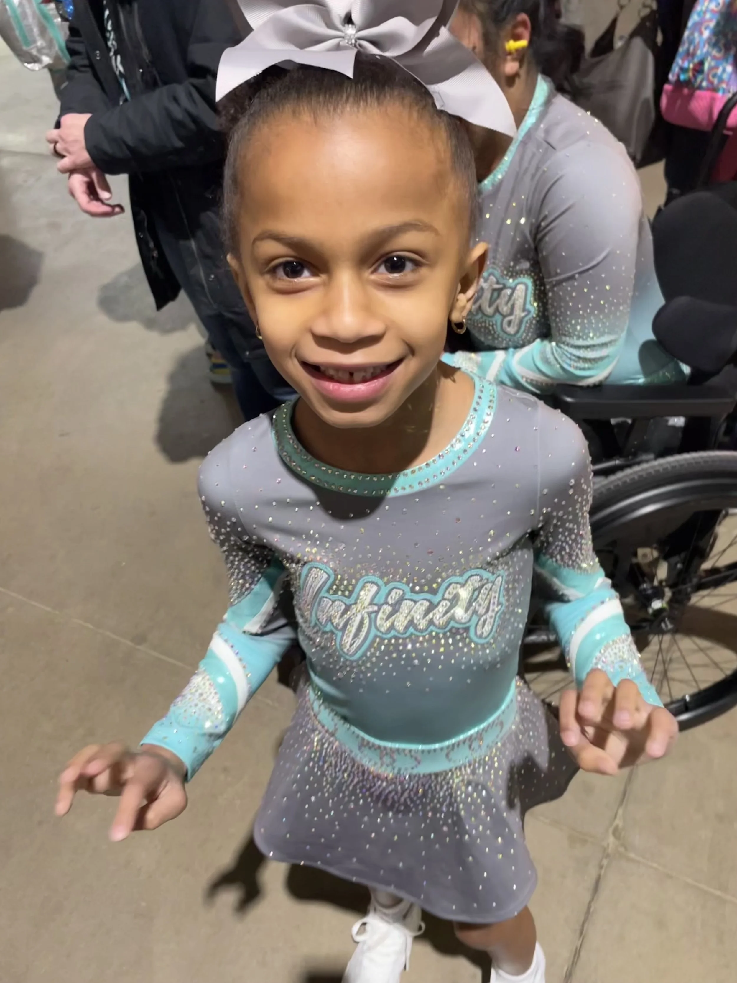 Young girl dressed in a sparkly cheerleader uniform with