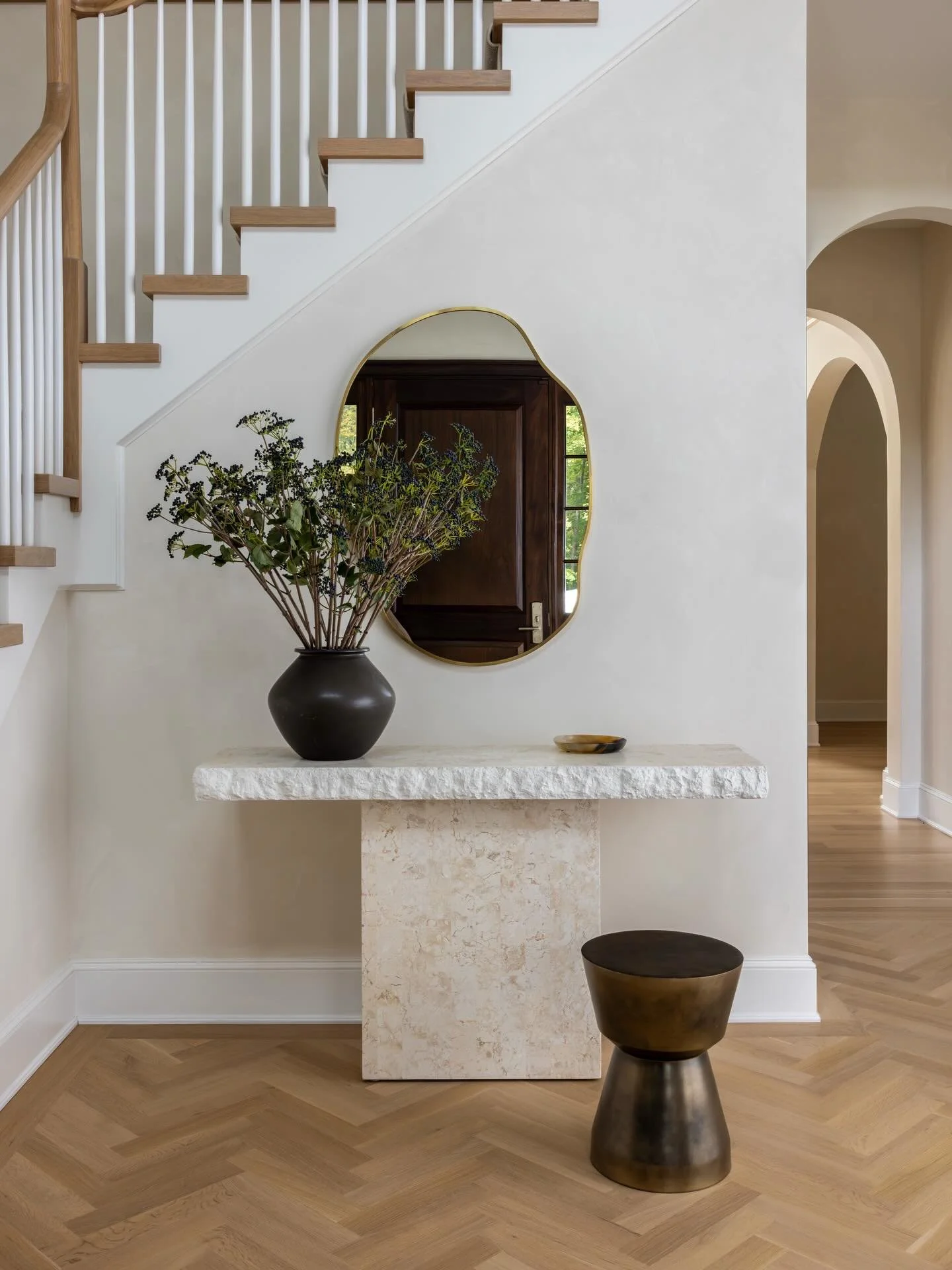 Letting the space lead: the arches, the floors, the height, the warmth.

Soft, intentional, and layered just enough.

A natural stone console and a mirror that quietly echo the architecture&mdash;each detail letting the space reveal itself from the v